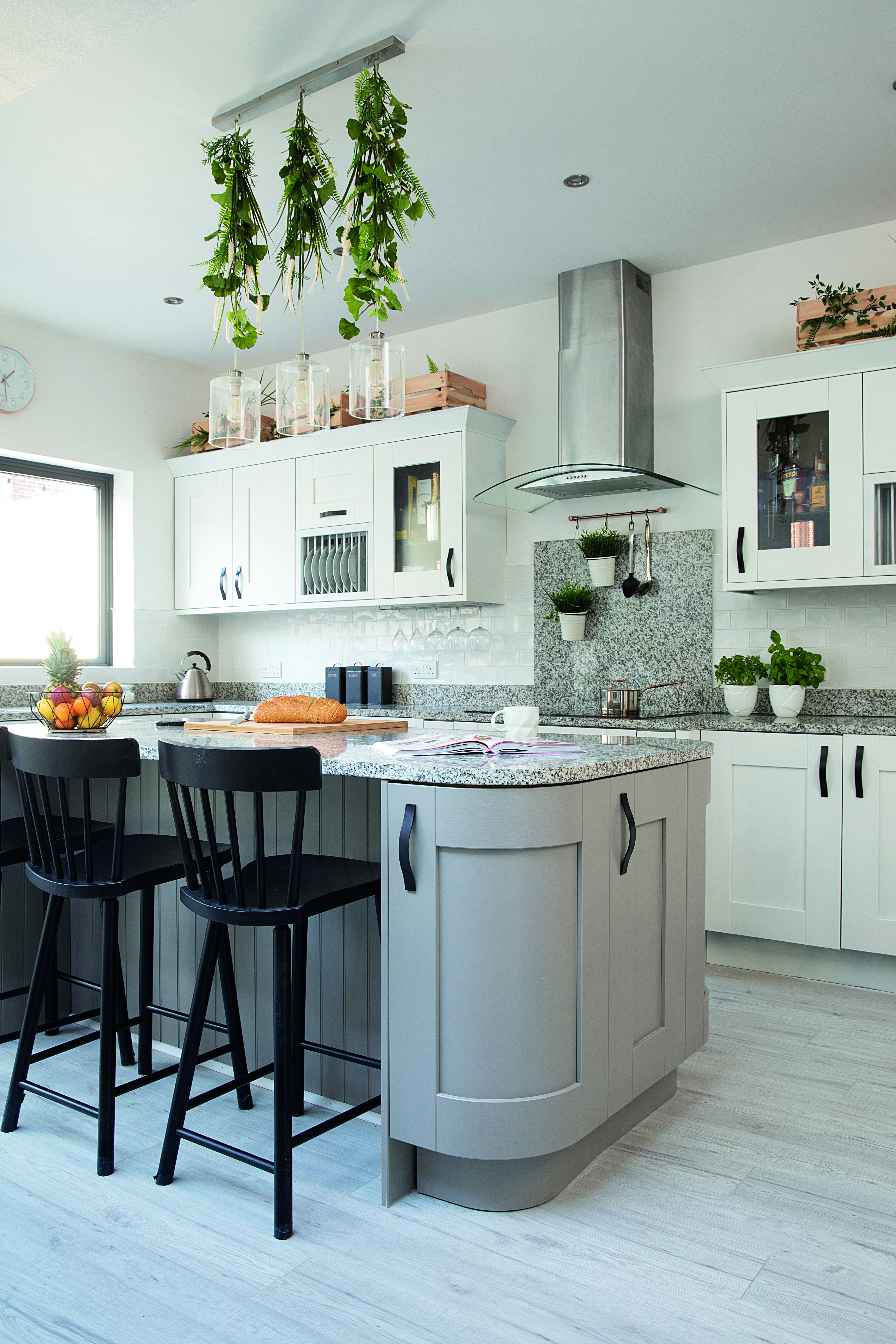 There was a lot of grey in the room and we wanted to break it up, so we sprayed the outer units white to make it even lighter and painted the handles black' explains Charlotte White kitchen units and black dining chairs