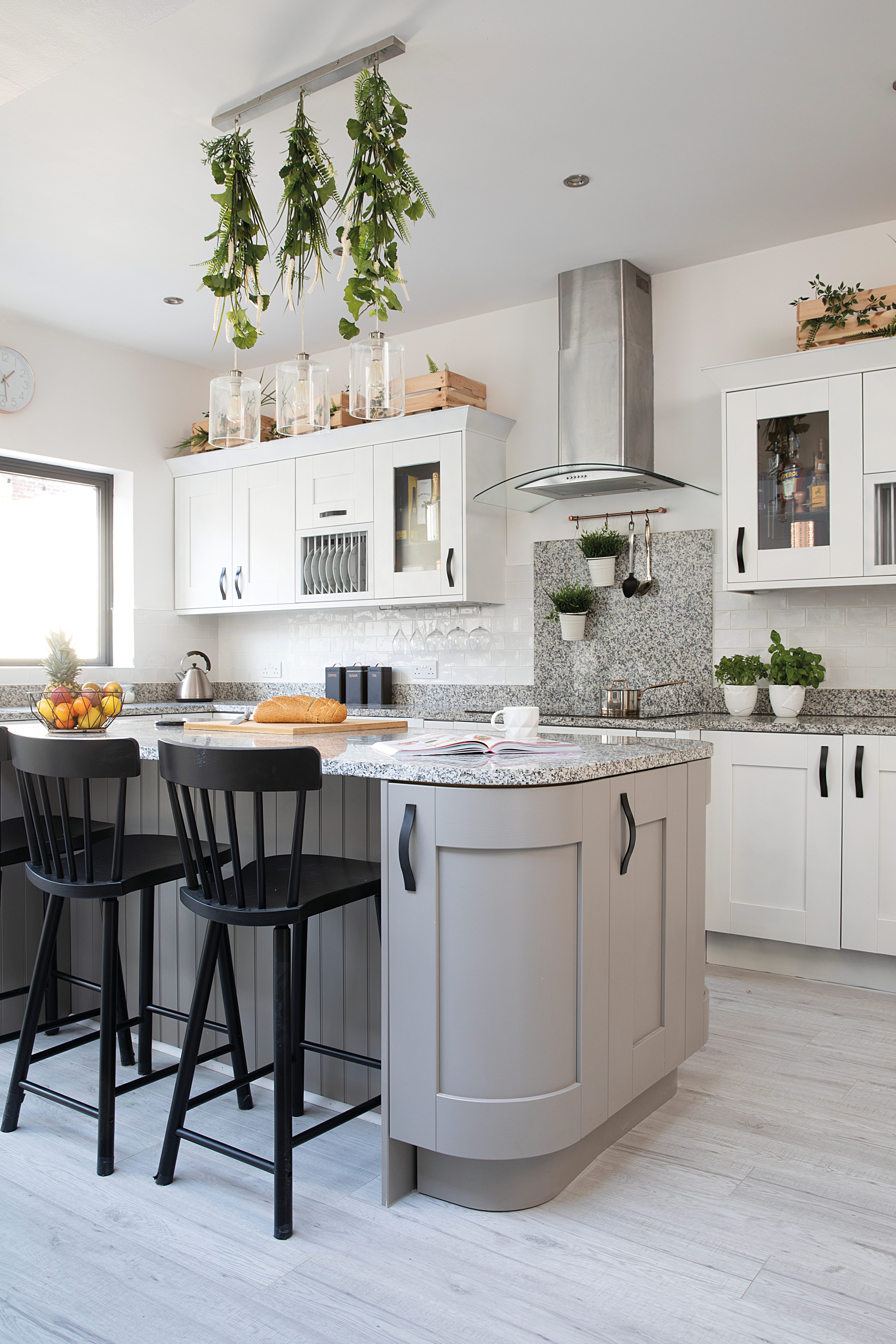 There was a lot of grey in the room and we wanted to break it up, so we sprayed the outer units white to make it even lighter and painted the handles black' explains Charlotte White kitchen units and black dining chairs