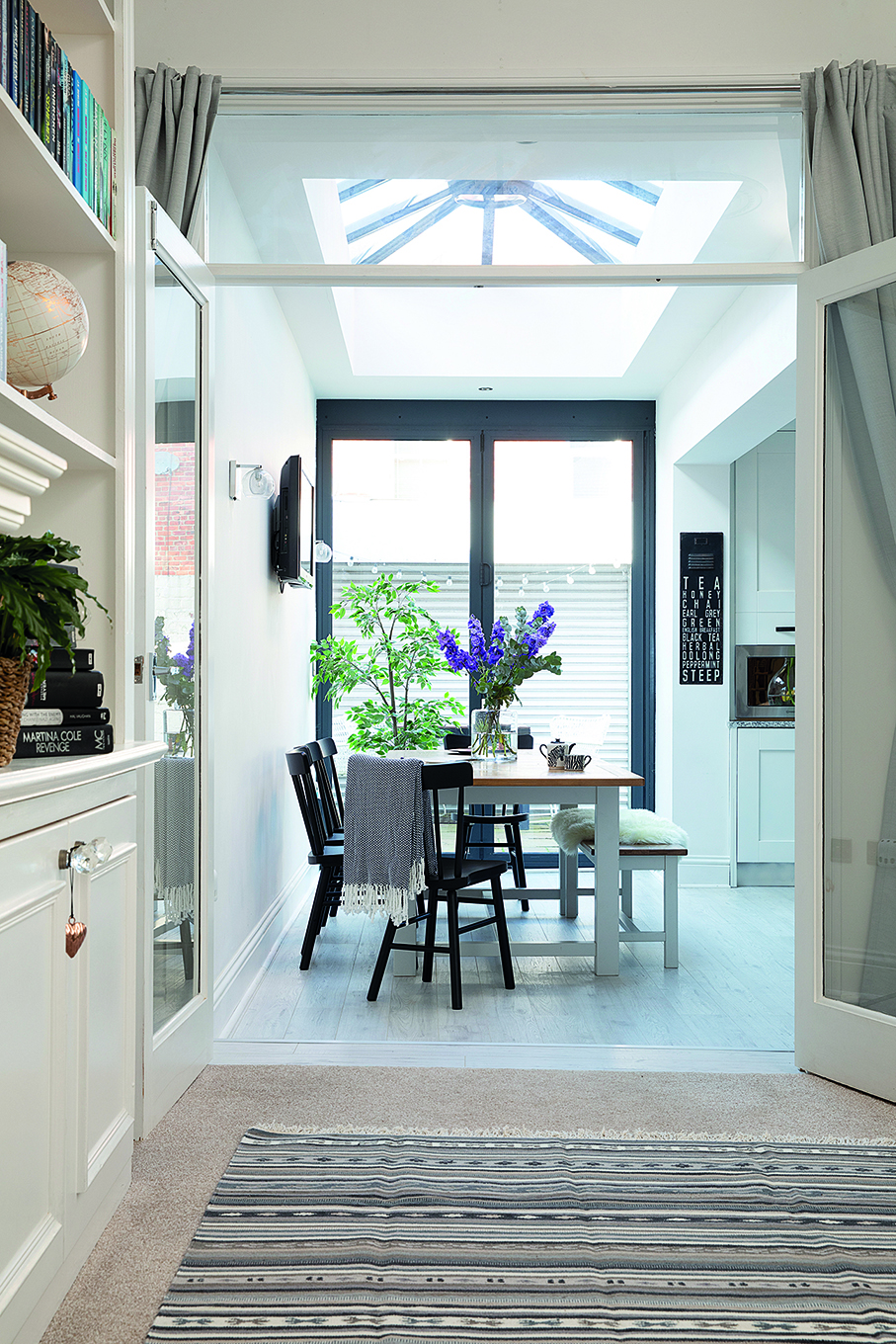 As the kitchen-diner had already been extended into the side return by the previous owners, Charlotte and Jonathan benefited from a lovely, light spacious room. Perfect for entertaining, it features a rustic dining table and bench from Furniture Village teamed with black IKEA chairs for definition A kitchen-diner with a rustic dining table and bench from furniture village