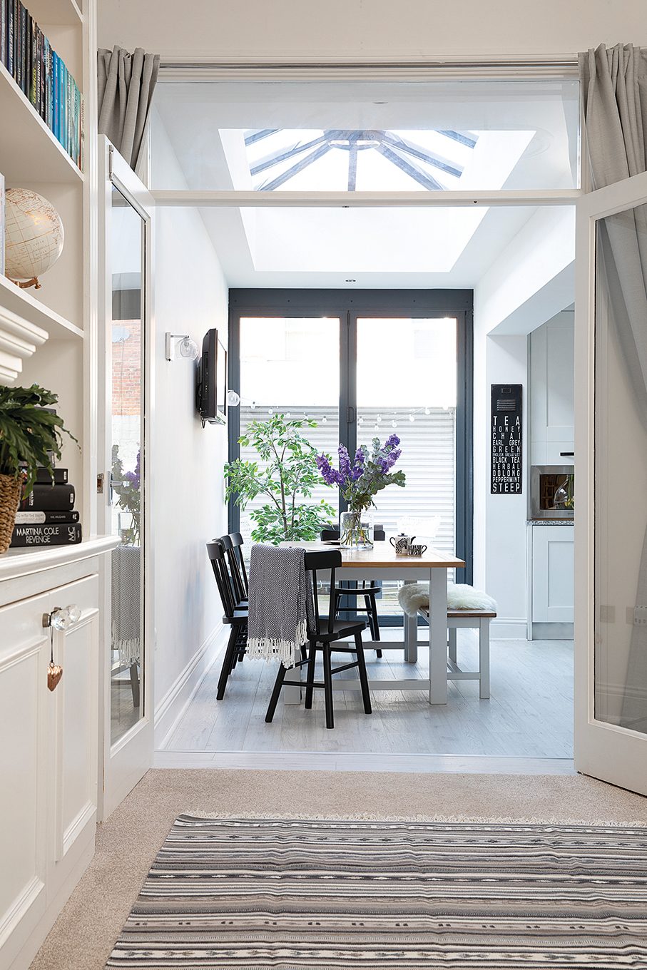 As the kitchen-diner had already been extended into the side return by the previous owners, Charlotte and Jonathan benefited from a lovely, light spacious room. Perfect for entertaining, it features a rustic dining table and bench from Furniture Village teamed with black IKEA chairs for definition A kitchen-diner with a rustic dining table and bench from furniture village