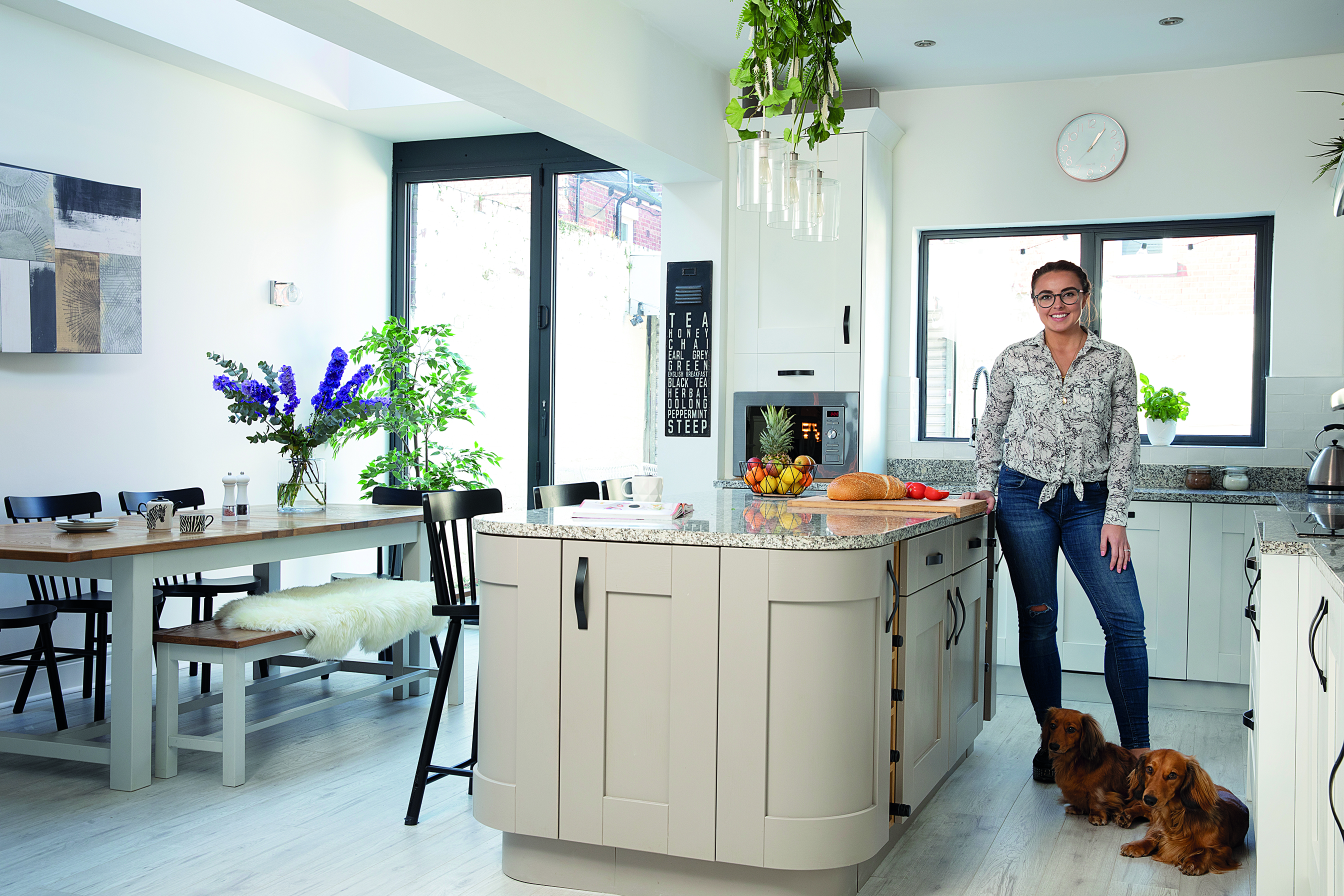 ‘I decorated the pendant lights above the island with fake plants and flowers,’ says Charlotte. ‘It was an idea I got straight from an IKEA showroom’ A cream kitchen island with decorated glass pendant lights
