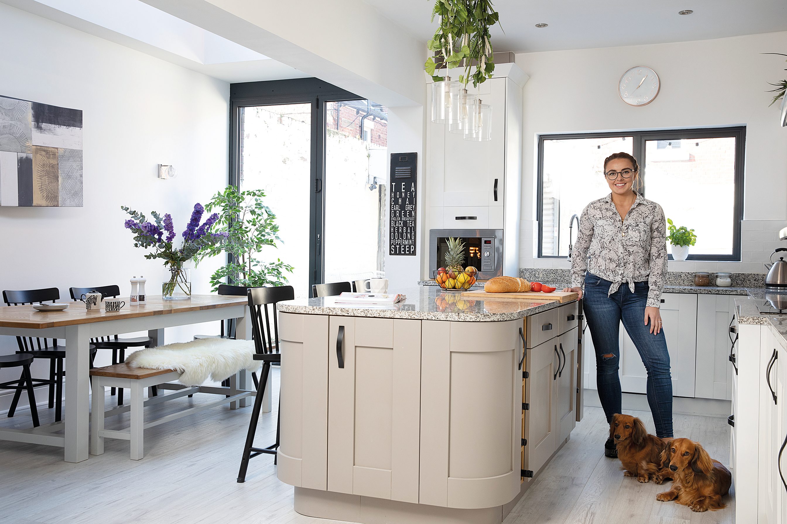 ‘I decorated the pendant lights above the island with fake plants and flowers,’ says Charlotte. ‘It was an idea I got straight from an IKEA showroom’ A cream kitchen island with decorated glass pendant lights