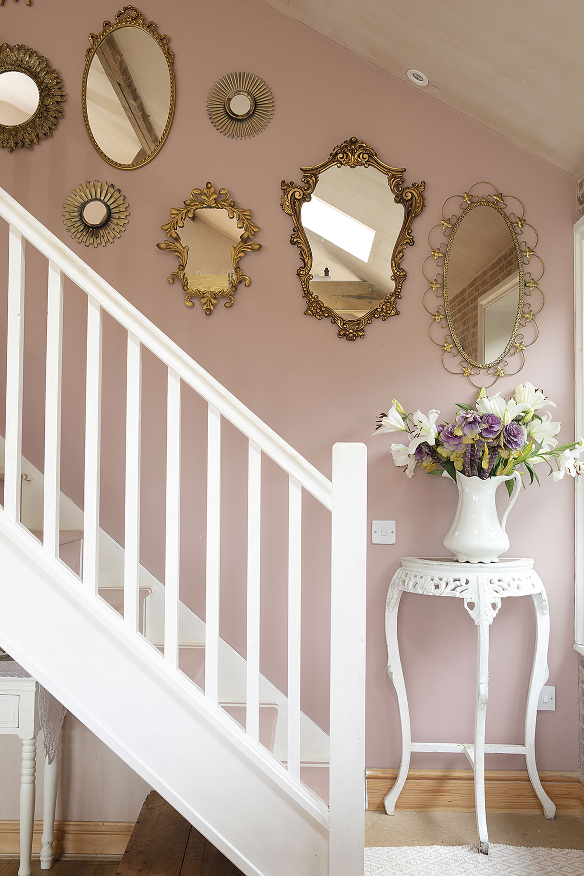 On the pink wall leading to the master bedroom, Sandra has hung a mixture of new and vintage mirrors. ‘The little round ones were £3.99 for a set of three from The Range. They were brown and I sprayed them gold to match the others,’ says Sandra. She painted the wall in pink chalk paint so her mirror collection would really pop On the pink wall leading to the master bedroom, Sandra has hung a mixture of new and vintage mirrors. ‘The little round ones were £3.99 for a set of three from The Range. They were brown and I sprayed them gold to match the others,’ says Sandra. She painted the wall in pink chalk paint so her mirror collection would really pop