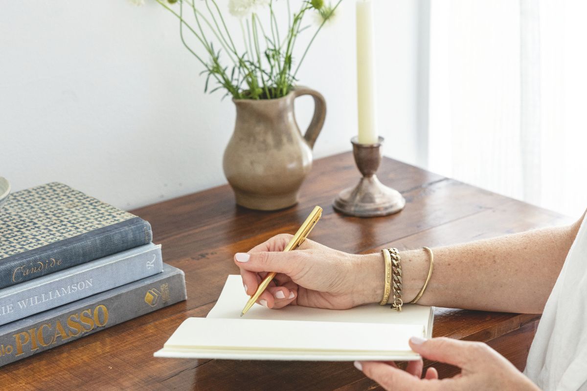 Person at desk writes in notebook