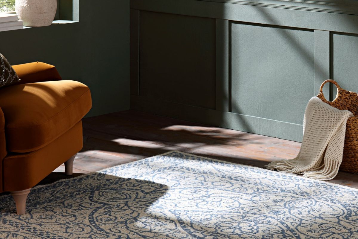 Rug on the floor with chair and rattan basket holding blanket