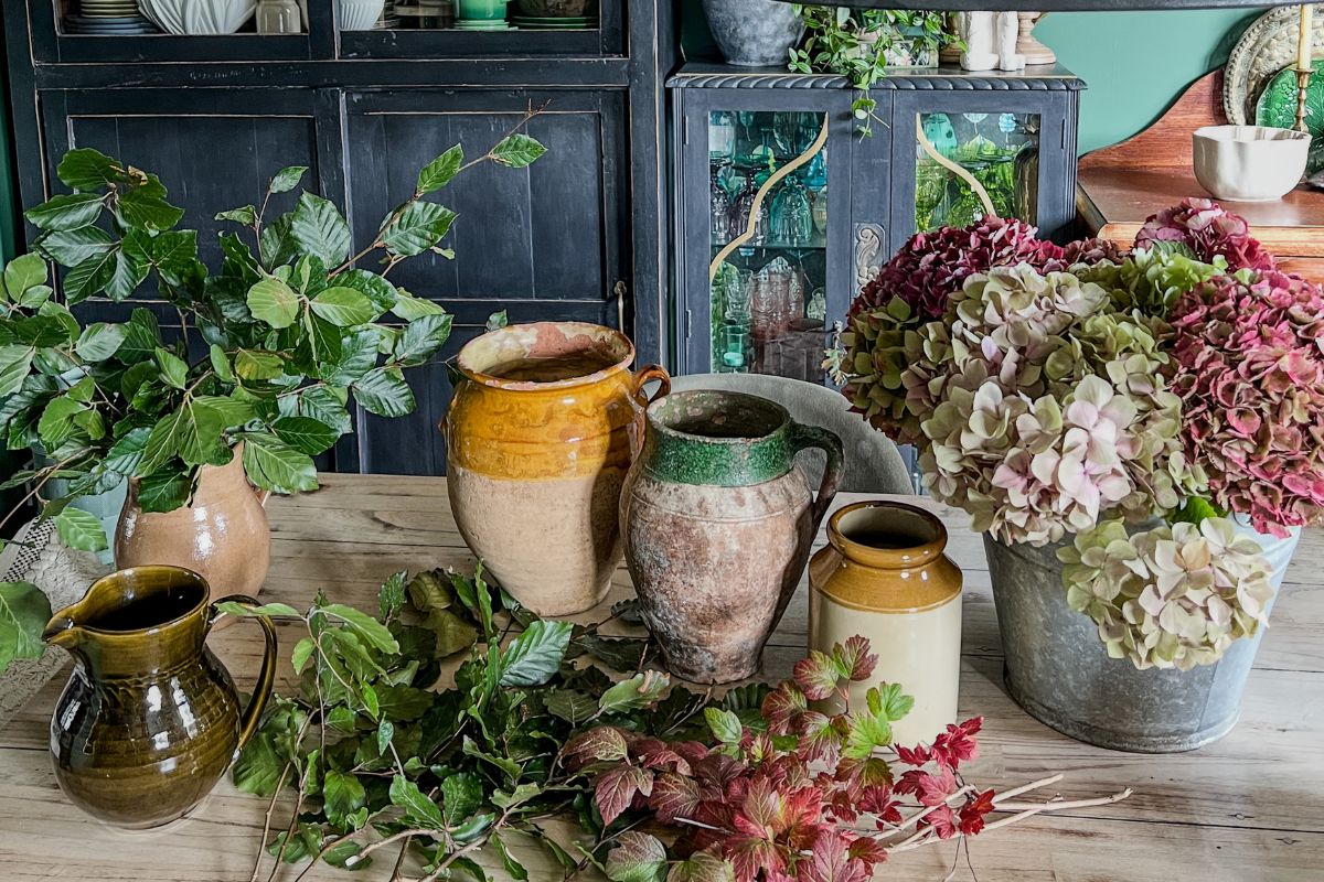 Flower arranging on a table with cupboards in background