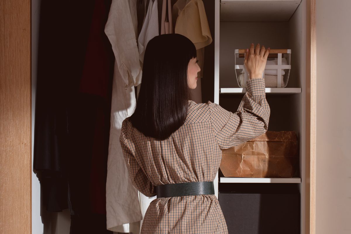 Marie Kondo looks at boxes in a wardrobe 