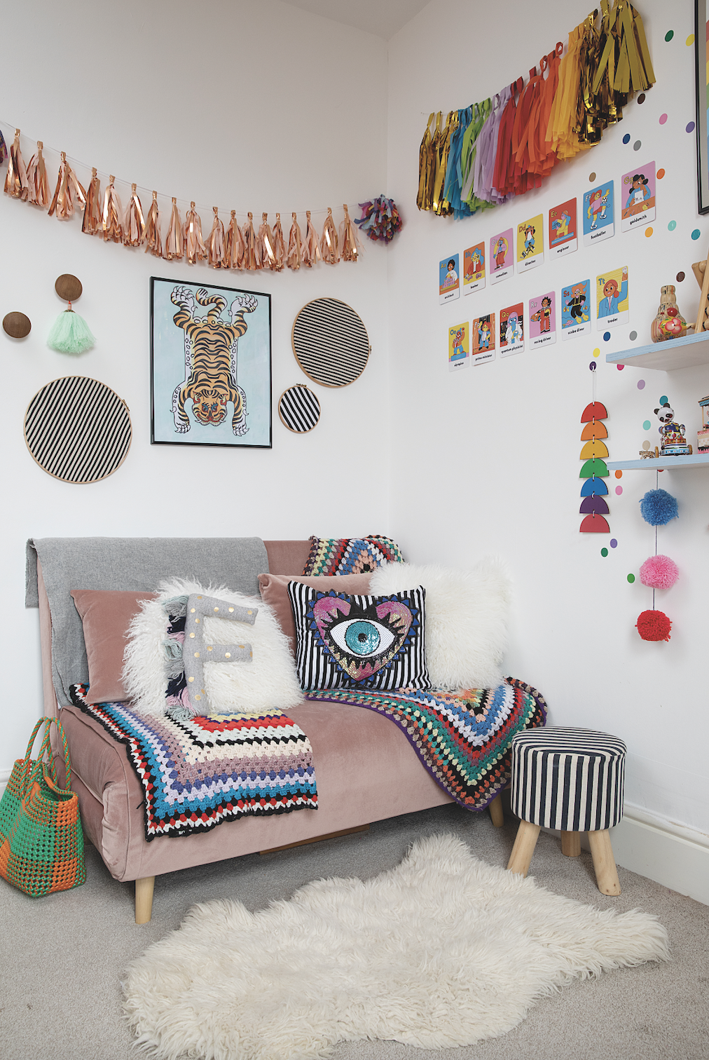 The pink sofa pulls out into a small double bed for visitors. Above it is a watercolour of a tiger by Suzy and fabric scraps framed in embroidery hoops. One of her favourite buys is the GALphabet flash cards by Boss Babs displayed on the wall, which depict women in various professions to inspire Frida Bedroom makeover: 'Getting creative on a budget is my passion'