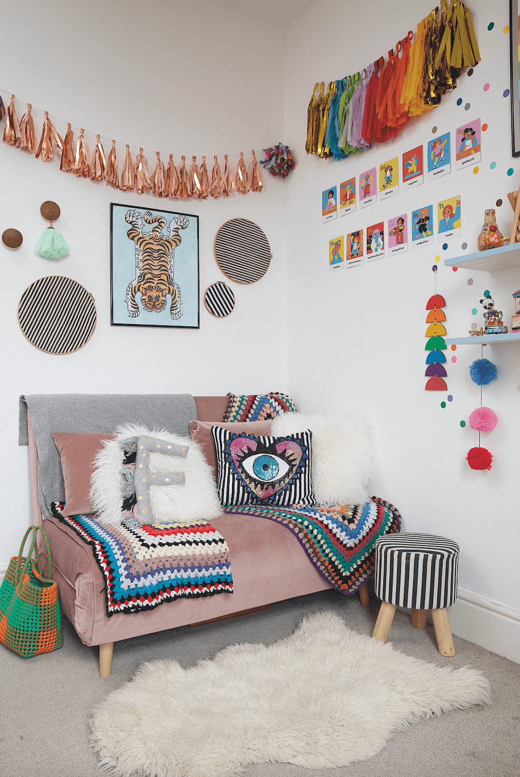 The pink sofa pulls out into a small double bed for visitors. Above it is a watercolour of a tiger by Suzy and fabric scraps framed in embroidery hoops. One of her favourite buys is the GALphabet flash cards by Boss Babs displayed on the wall, which depict women in various professions to inspire Frida Bedroom makeover: 'Getting creative on a budget is my passion'