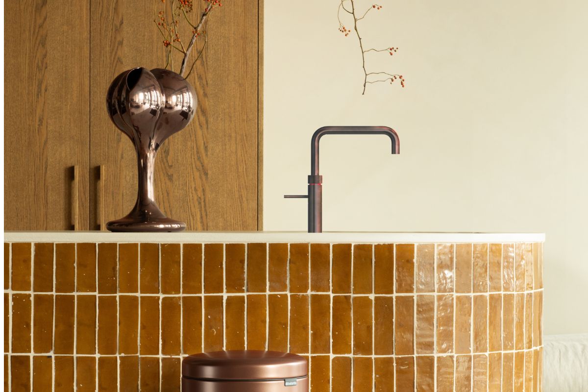 Bronze bin with big tiled kitchen surface behind