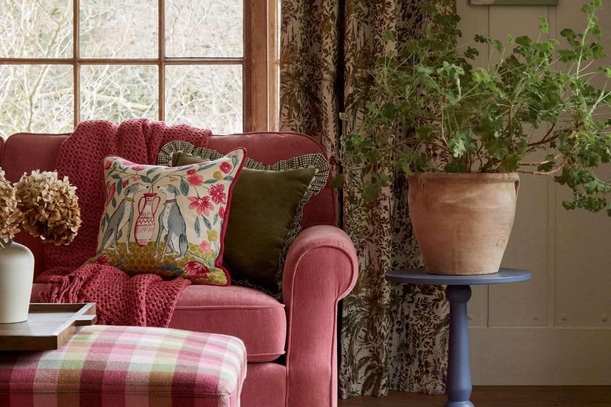 Sofa with cushions with big plant next to it
