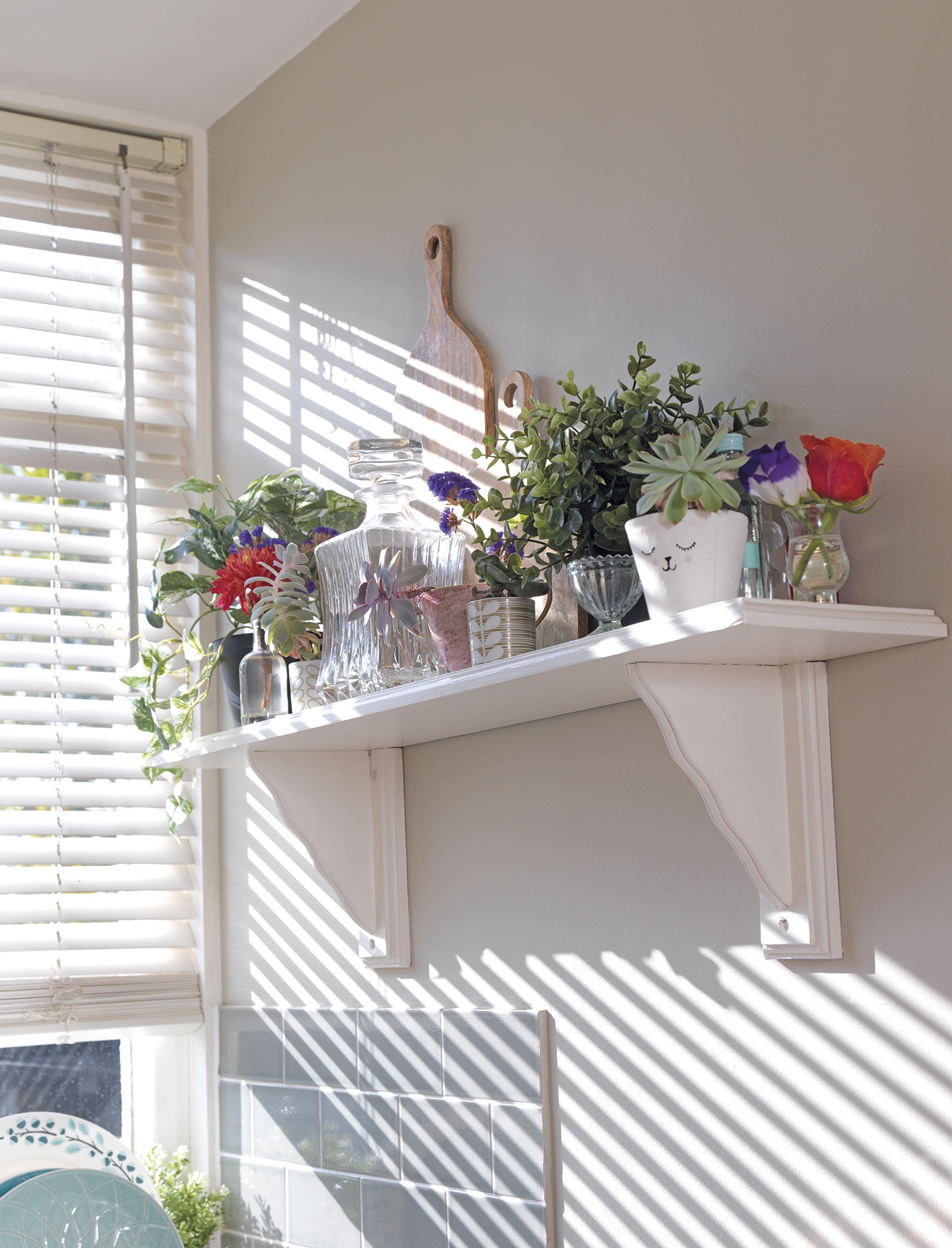 With a combination of chopping boards and glassware, interspersed with succulents, little posies and artificial plants, the shelf above the sink is cleverly arranged, without looking too cluttered With a combination of chopping boards and glassware, interspersed with succulents, little posies and artificial plants, the shelf above the sink is cleverly arranged, without looking too cluttered