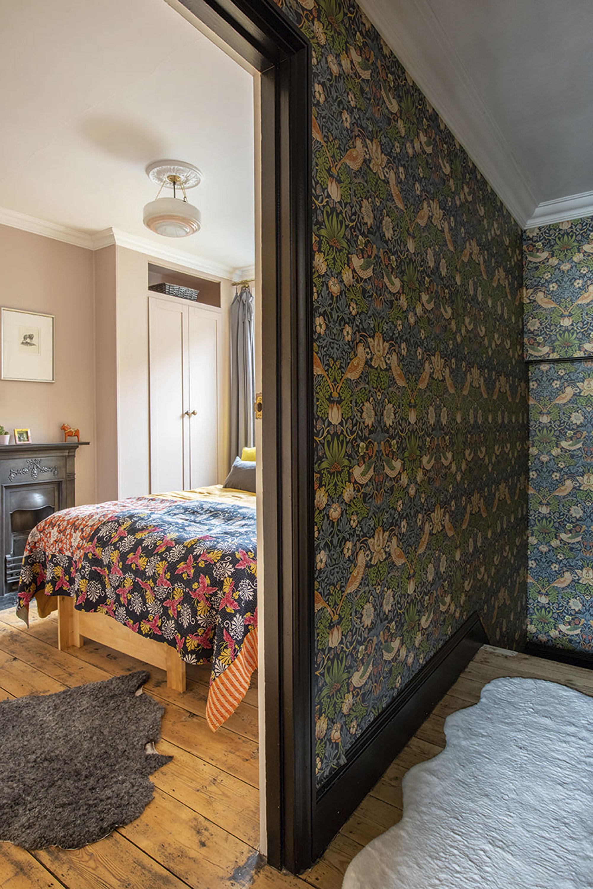 'Renovating gave us a blank canvas for our colourful, creative home' The Strawberry Thief wallpaper runs up the stairs into the first-floor hallway, framed by black skirting and a deep-stained staircase for a dramatic look