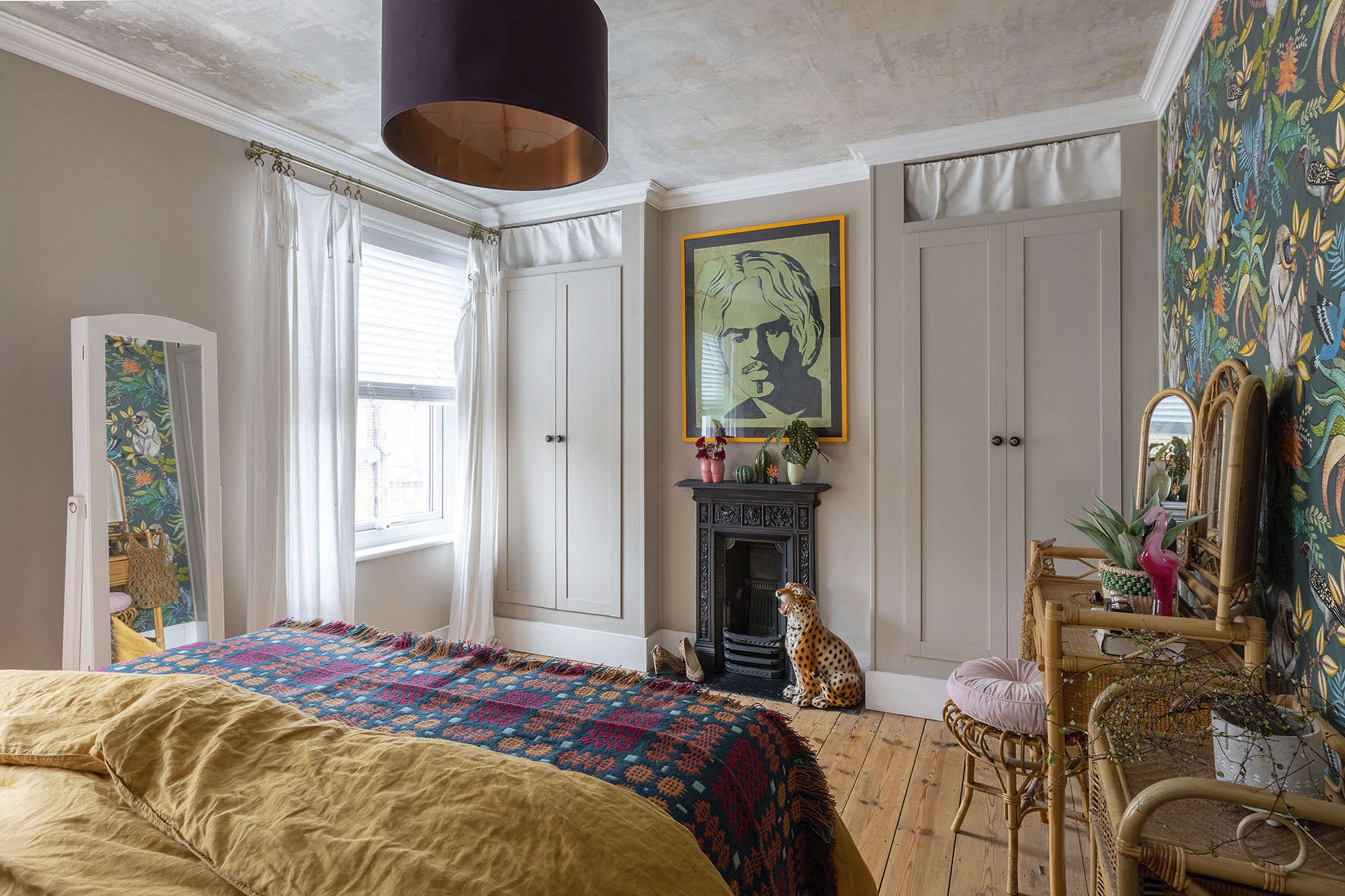 'Renovating gave us a blank canvas for our colourful, creative home' Carey and Johan designed the wardrobes in both bedrooms themselves by custom-building frames around IKEA doors, with an open shelf dressed with curtains to hide clutter away. The lampshade is from Love Frankie Ltd on Not On The High Street