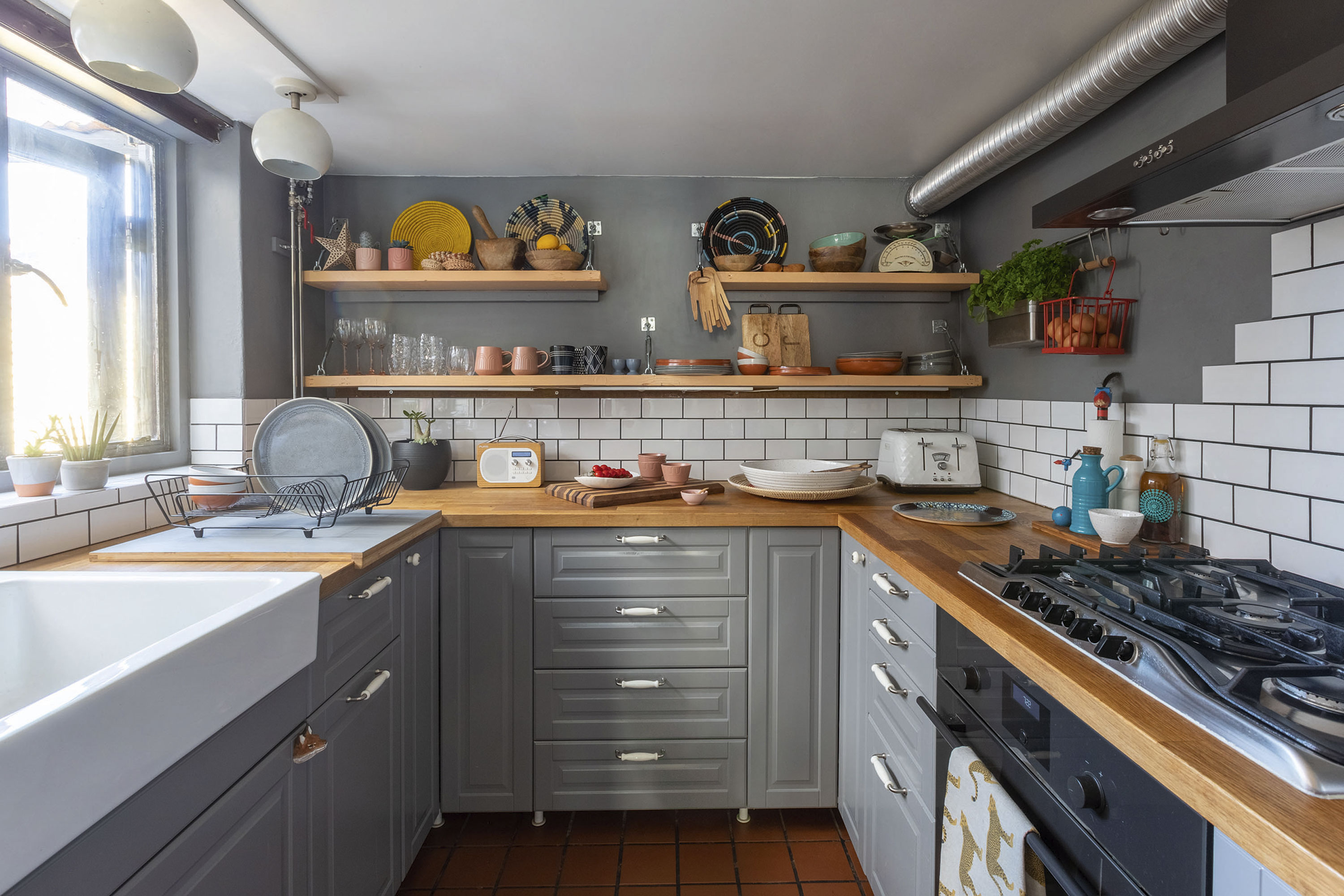 'Renovating gave us a blank canvas for our colourful, creative home' As in the rest of the house, Carey has combined classic and modern design details in the kitchen, choosing a contemporary steel grey for the walls and cabinets and adding a traditional, farmhouse-style sink