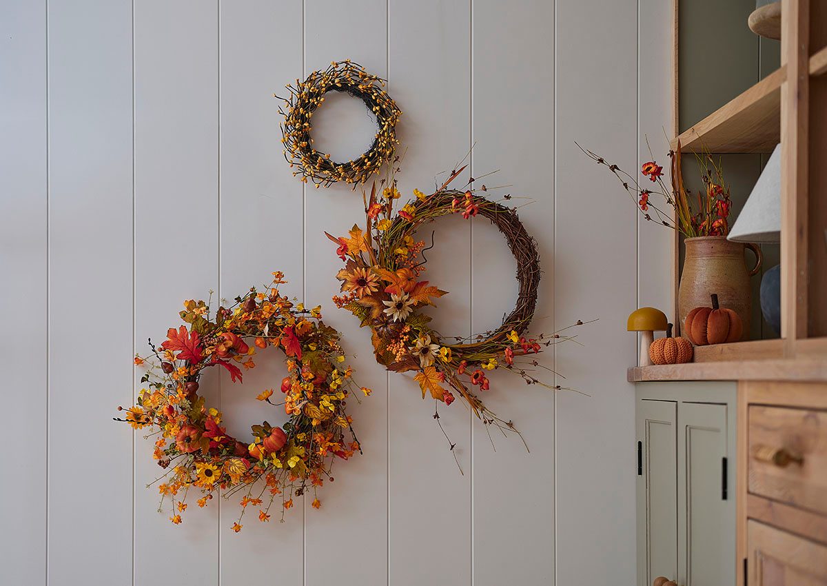 Three different-sized floral wreaths hanging on a wall