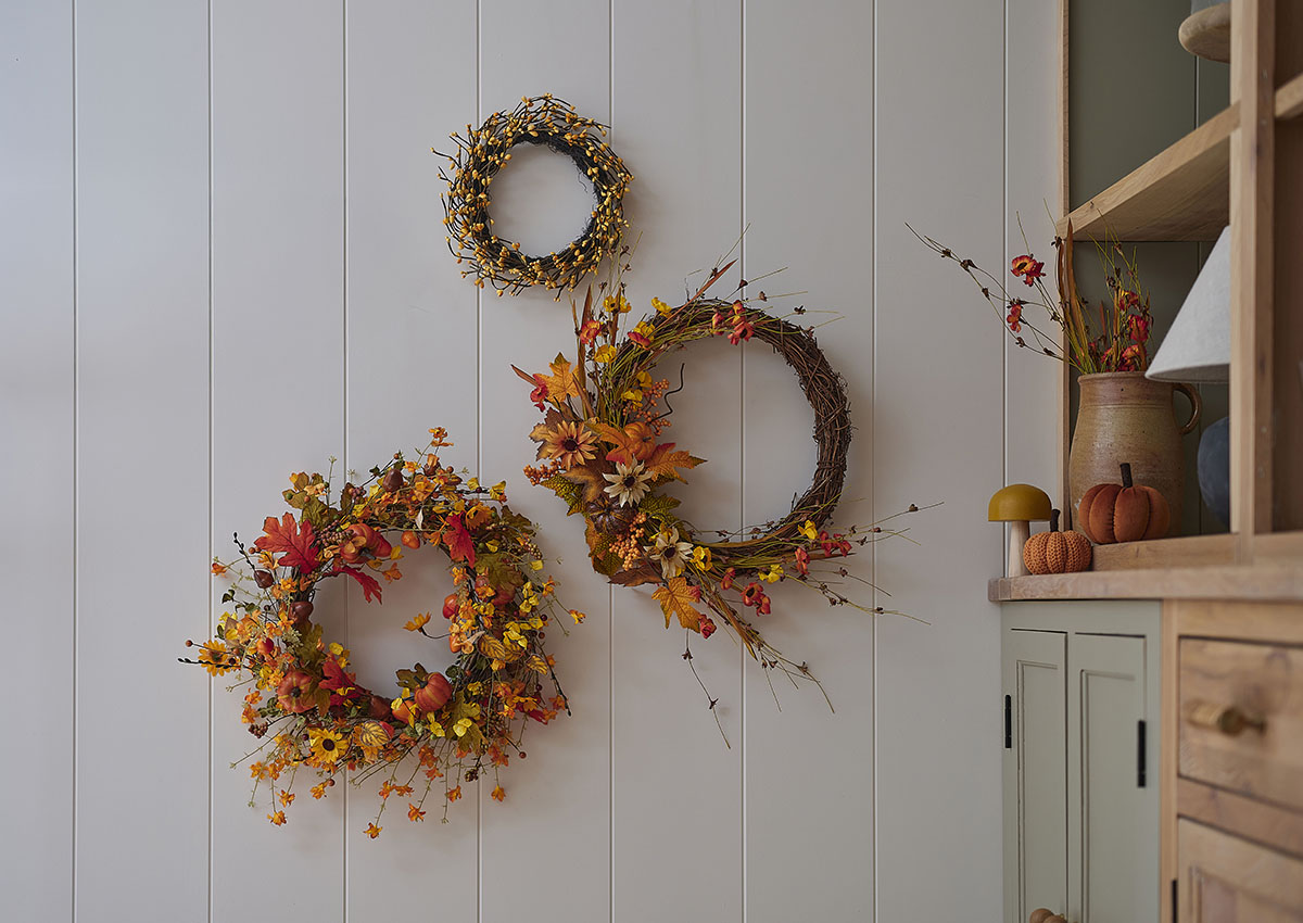 Three different-sized floral wreaths hanging on a wall