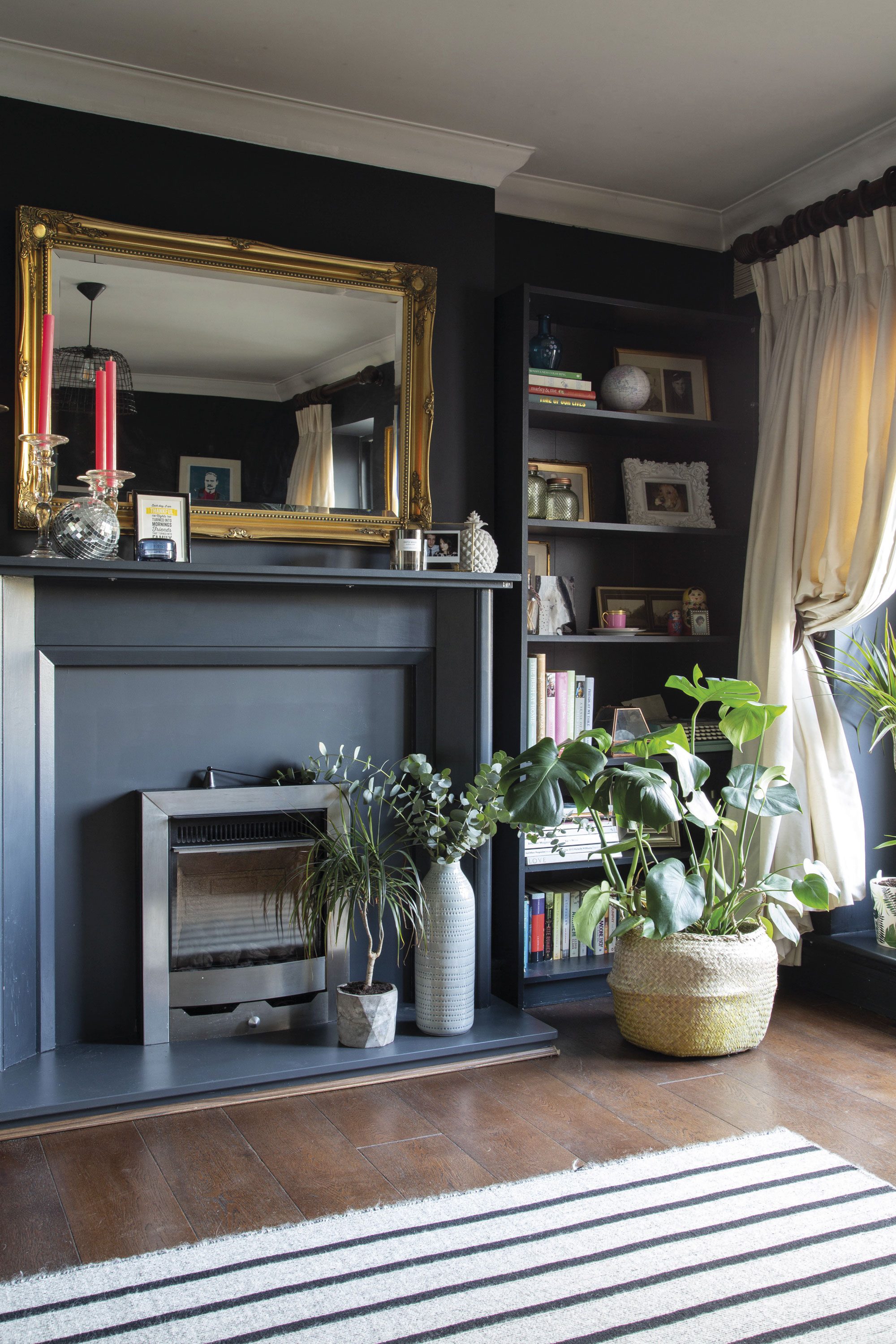 Dark walls together with heavy drapes, brightly coloured accessories and hints of brass create the ultimate cosy living room scheme