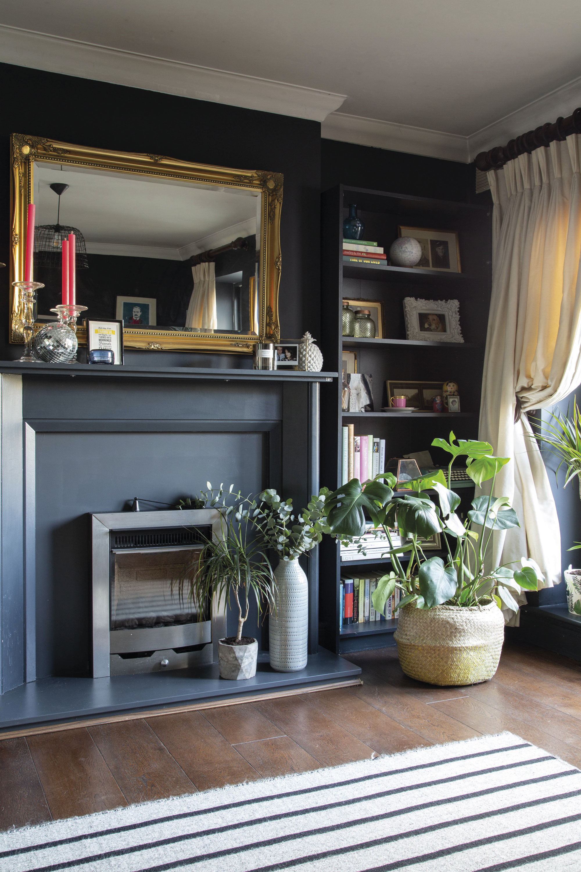 Dark walls together with heavy drapes, brightly coloured accessories and hints of brass create the ultimate cosy living room scheme