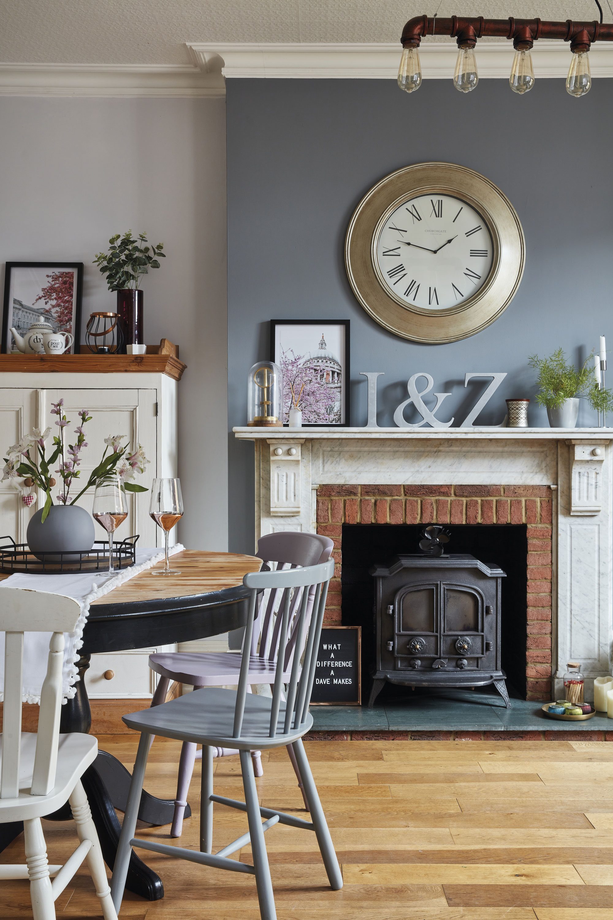 The dining table is one of Sharon’s many upcycling projects, which she painted in black Rust-Oleum paint. She then turned her attention to the chairs. ‘I used leftover paint from my front door for some of the dining chairs because I wanted to bring more of the lilac colour into my home.’ Above the fireplace hangs an oversized clock from Dunelm The dining table is one of Sharon’s many upcycling projects, which she painted in black Rust-Oleum paint. She then turned her attention to the chairs. ‘I used leftover paint from my front door for some of the dining chairs because I wanted to bring more of the lilac colour into my home.’ Above the fireplace hangs an oversized clock from Dunelm