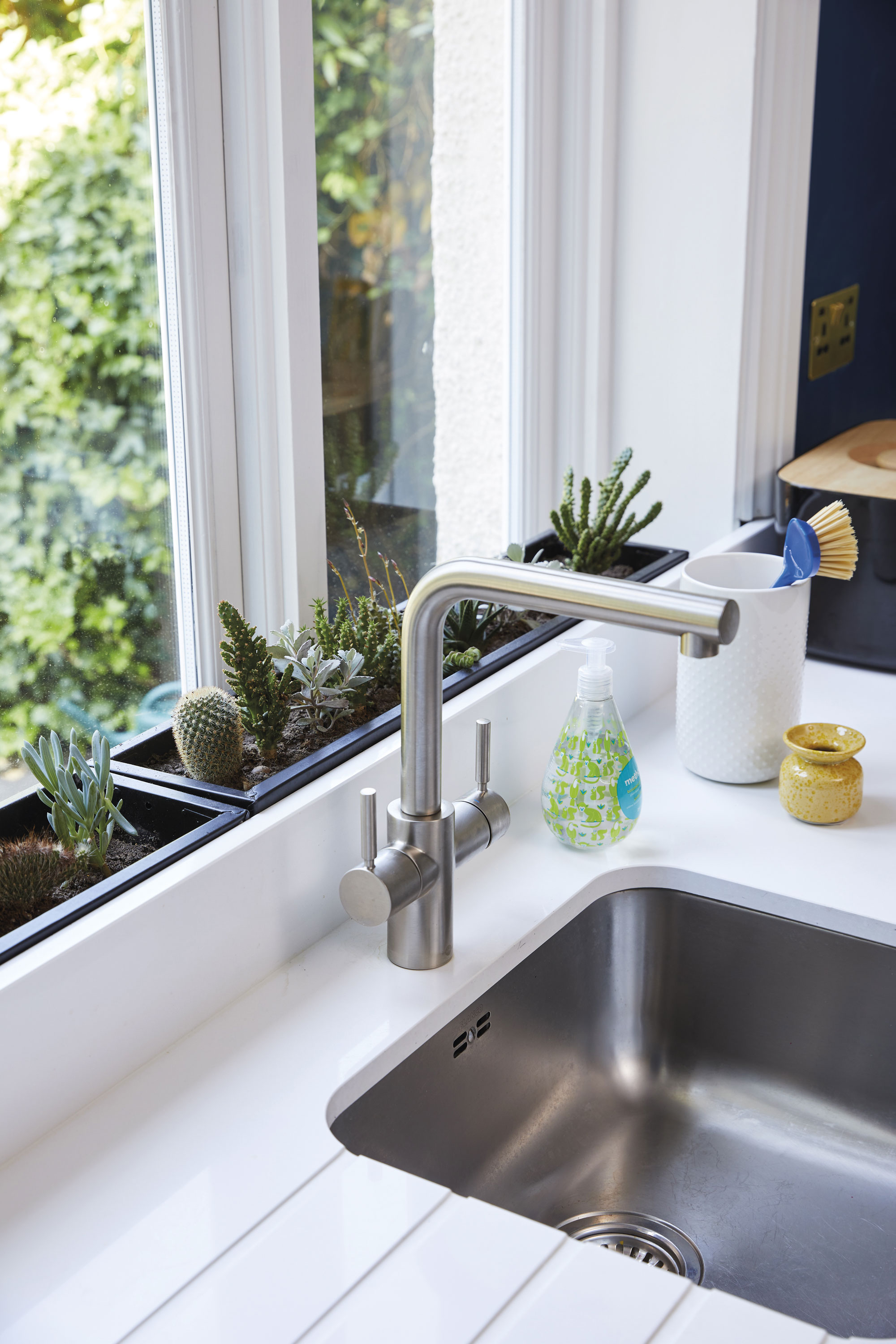 Ally turned a discrepancy in height between the worktop and the window into a feature, by simply adding two troughs. She planted on-trend cacti and succulents, but herbs would work equally well Ally turned a discrepancy in height between the worktop and the window into a feature, by simply adding two troughs. She planted on-trend cacti and succulents, but herbs would work equally well