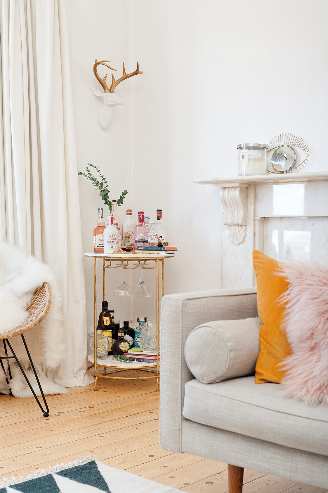 Home makeover: 'Our flat has bags of character!' The gold valet bar trolley, which complements the other metallic accessories in the room, is from West Elm and is home to a range of bar accessories and bottled drinks – some propped up on decorative books. It makes this corner the perfect space for cocktails with friends