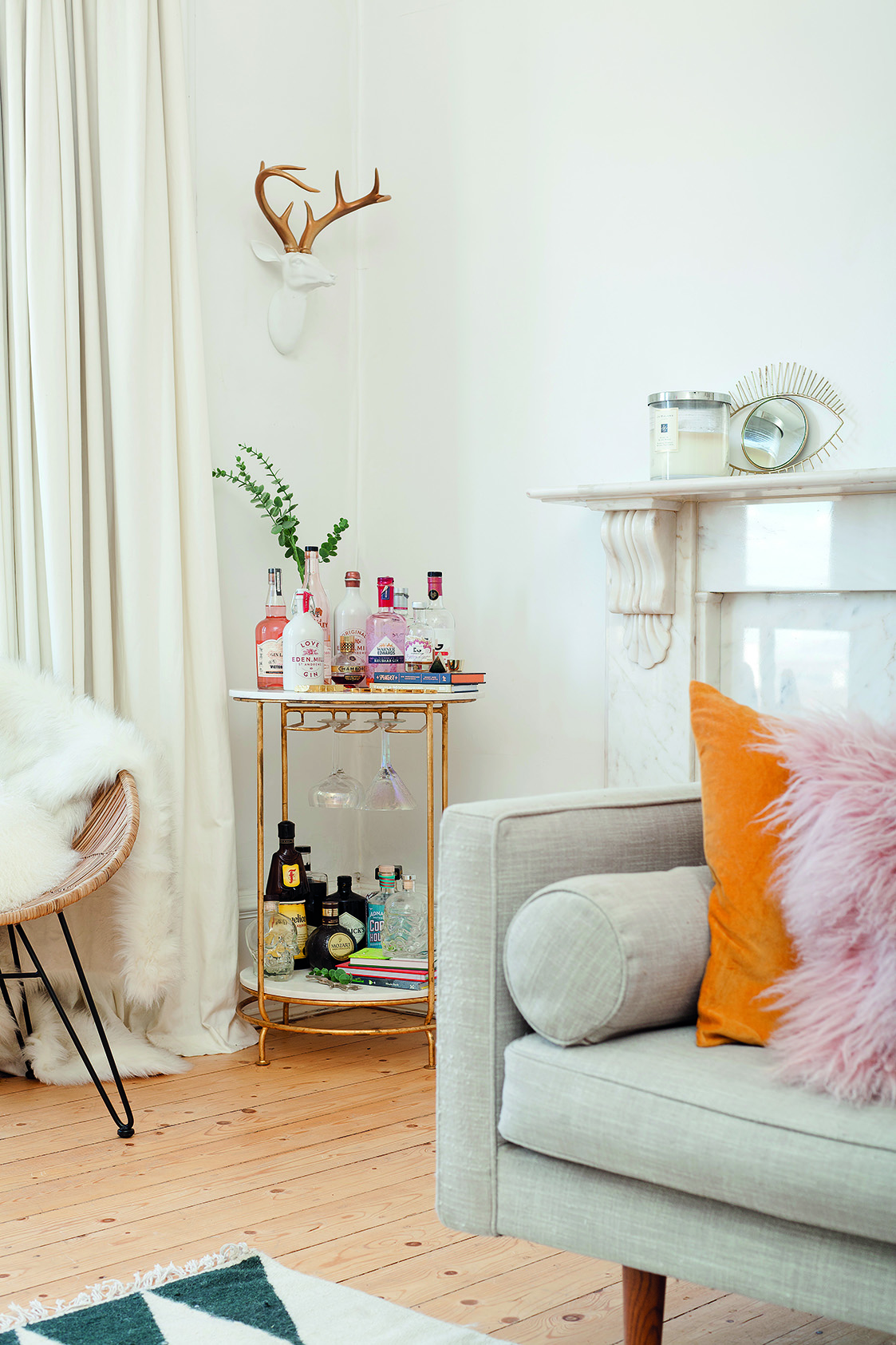 Home makeover: 'Our flat has bags of character!' The gold valet bar trolley, which complements the other metallic accessories in the room, is from West Elm and is home to a range of bar accessories and bottled drinks – some propped up on decorative books. It makes this corner the perfect space for cocktails with friends