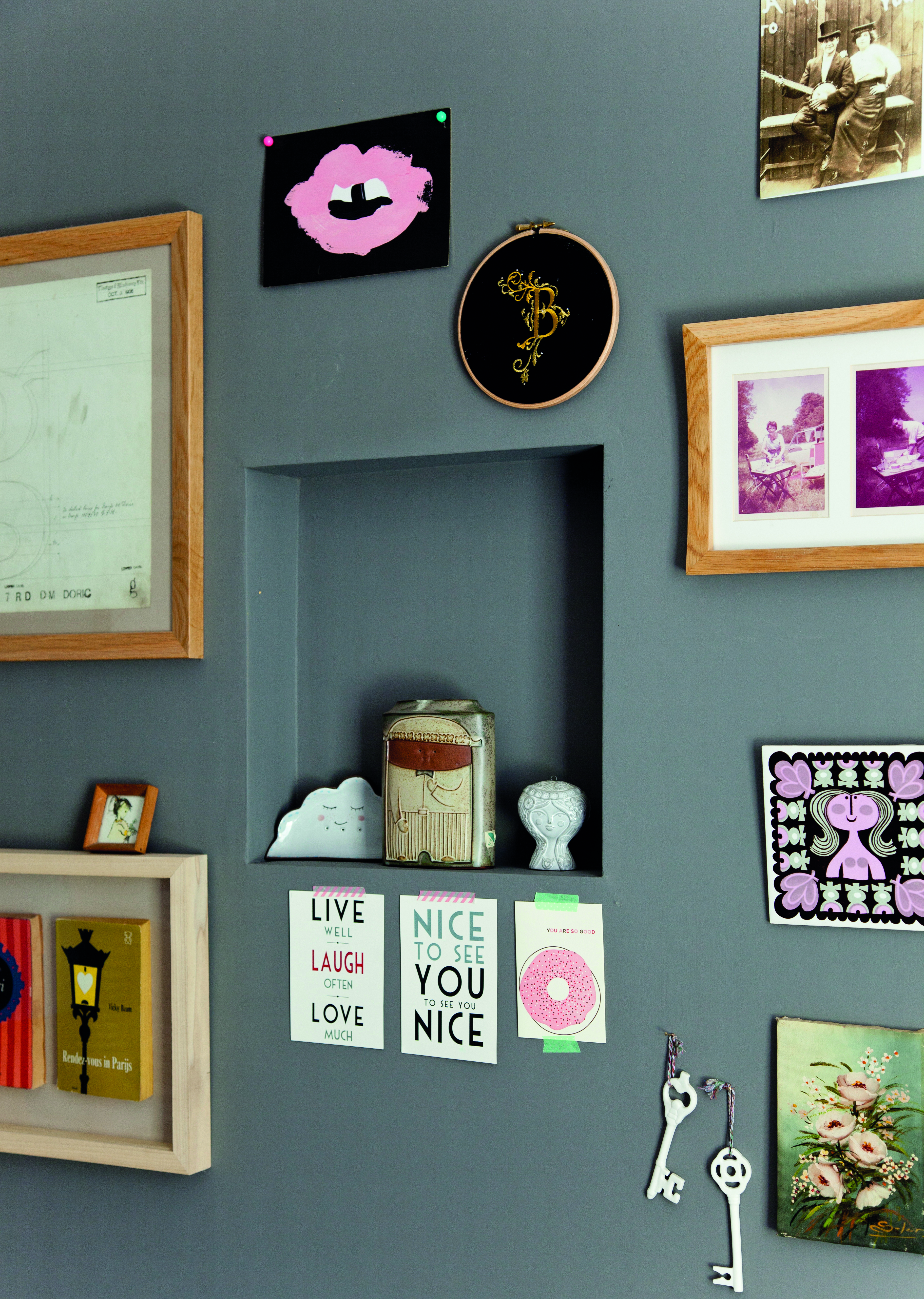 Christine showcases prints, photos, crafts and souvenirs behind the sofa, making stylish use of display niches set within the stud wall A grey wall displaying Christine's prints, photos, crafts and souvenirs