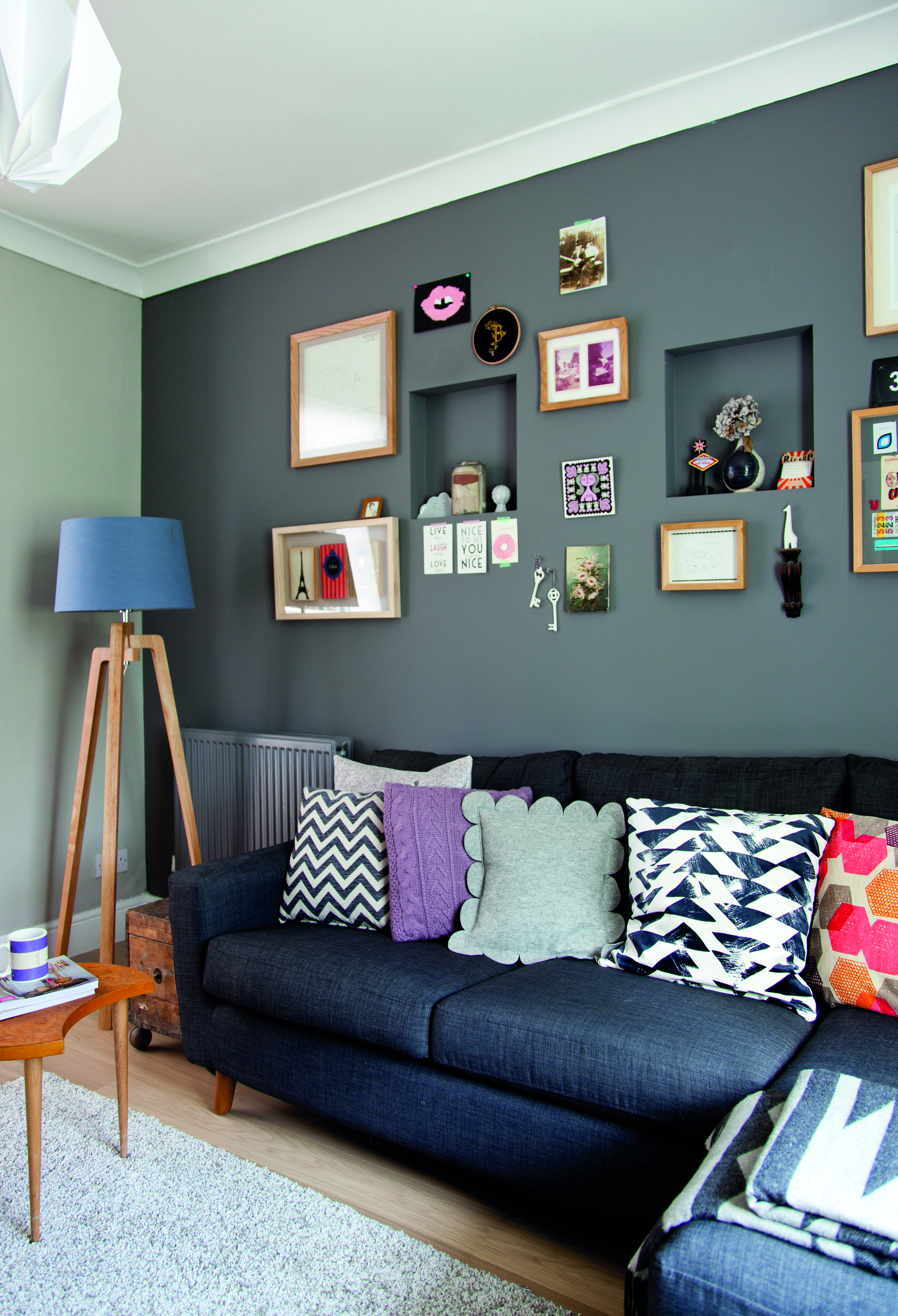 Reinstating the original hallway wall not only redefined the living space, but also eliminated draughts and privacy issues. Christine’s choice of a modular sofa helps make the most of limited space A dark charcoal modular sofa next to a floor lamp with a blue shade