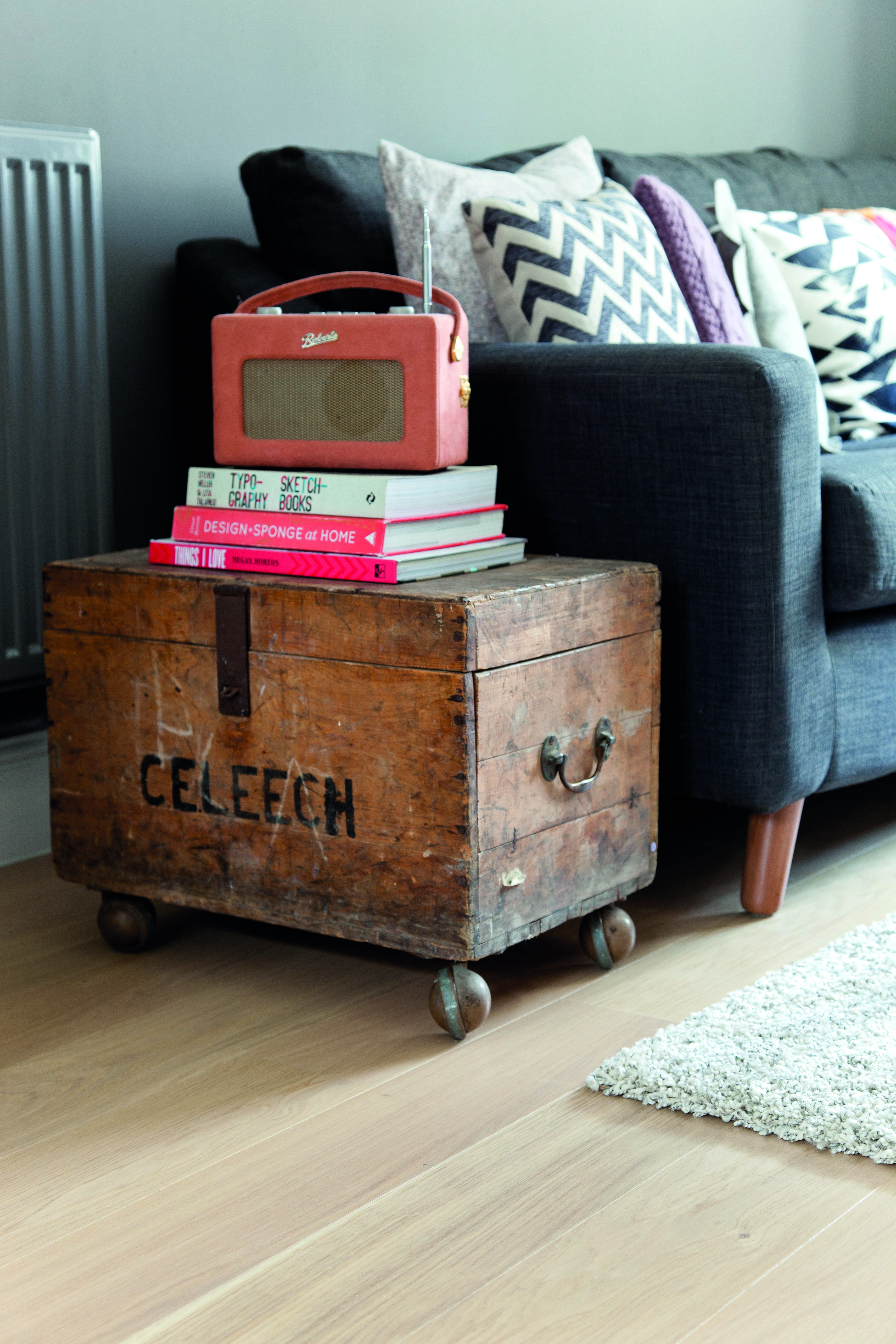 Christine added vintage pieces, such as this trunk from her parents’ house, to inject personality into the room A vintage trunk with books and an orange digital radio on top