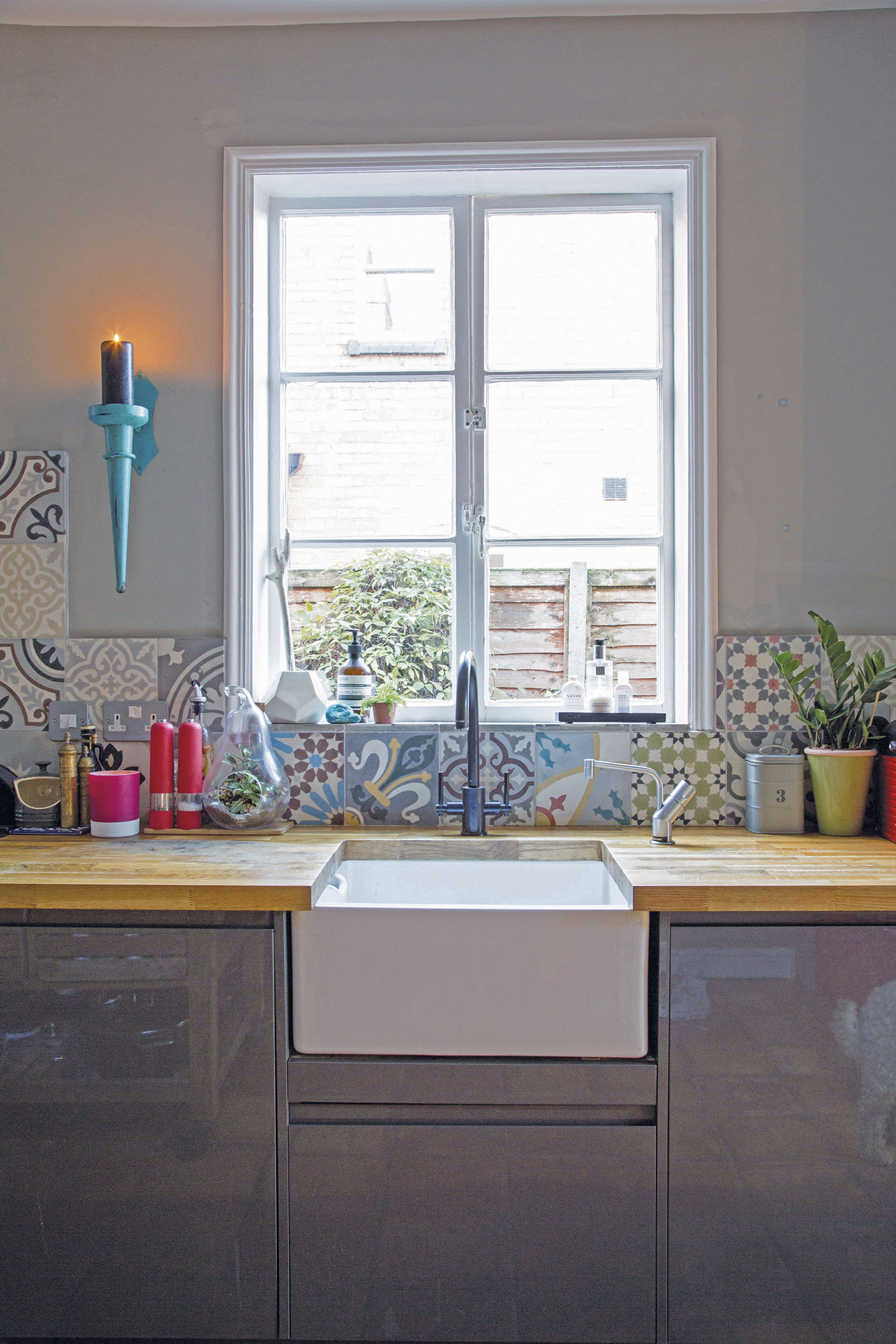 Farmhouse-style touches, such as the Belfast sink and patterned tiles soften the industrial-look kitchen-diner