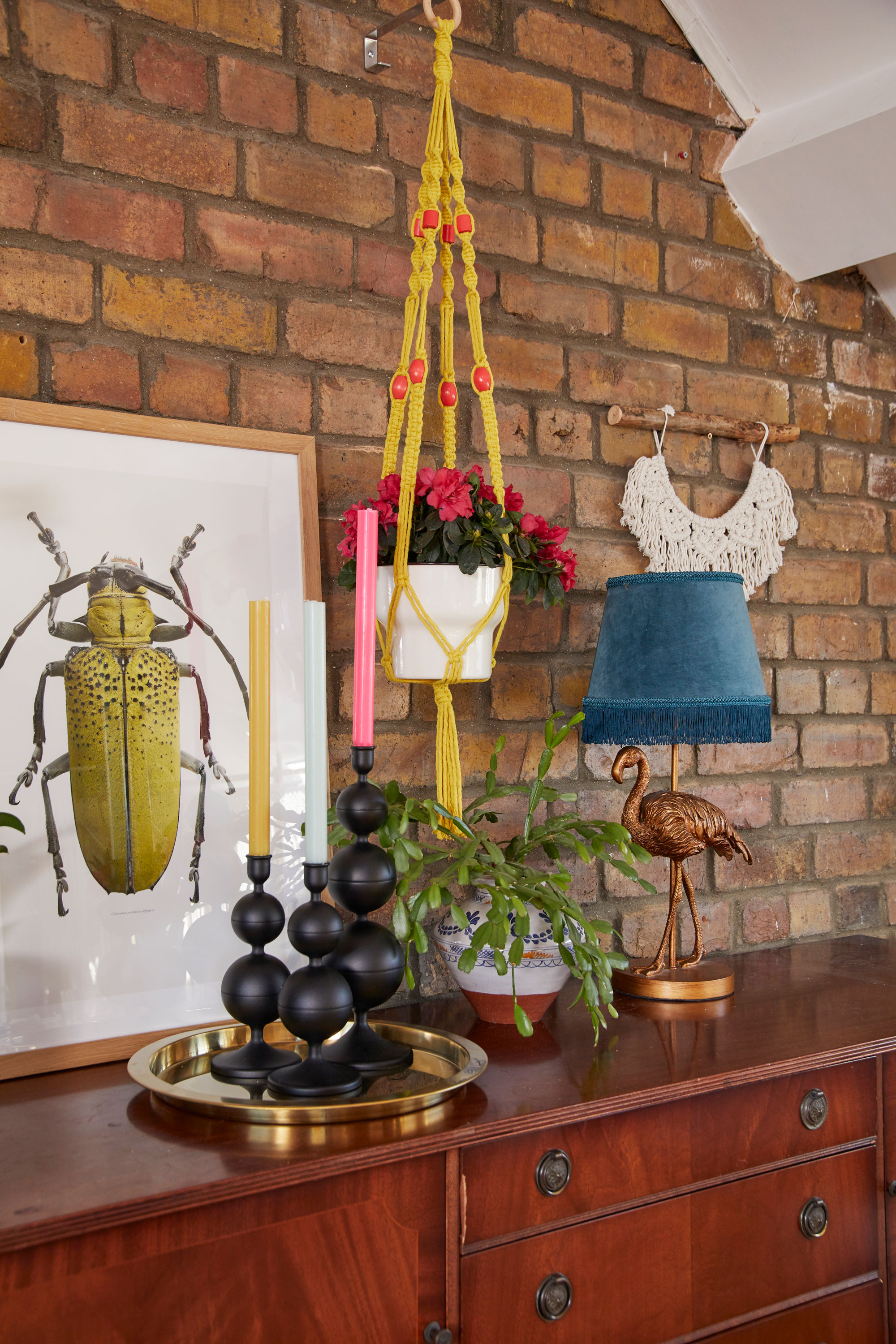 Style idea! Multicoloured candles inject a splash of colour to the trio of black IKEA candlesticks, which Emma has added to with vibrant yellow and turquoise accessories Living room makeover: 'My multi-use room sings with colour'