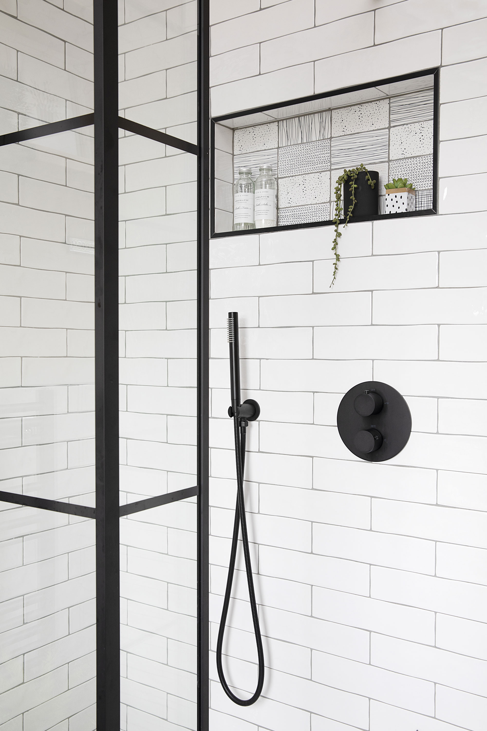 Quirky doodle motif tiles highlight the petite niche shelf, which is now Liz’s favourite part of the bathroom Quirky doodle motif tiles highlight the petite niche shelf, which is now Liz’s favourite part of the bathroom