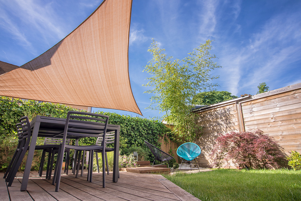 Modern house terrace in summer with table and shade sail