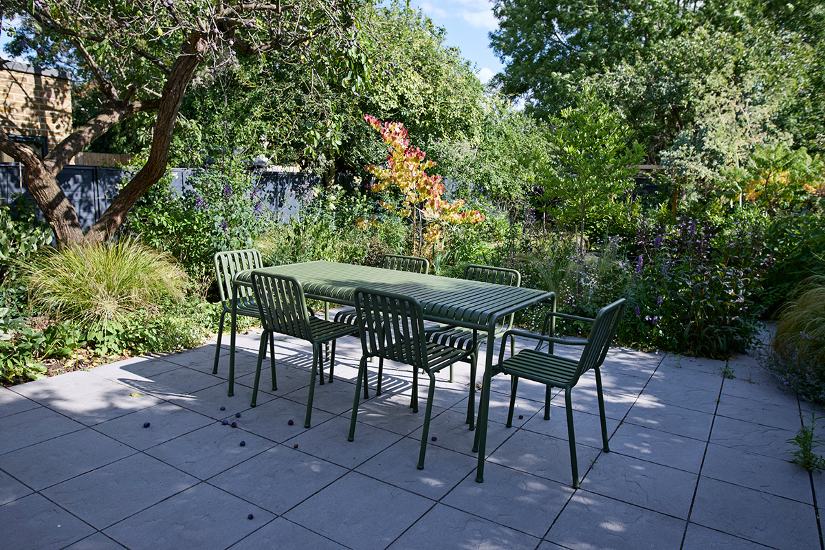 View of chairs arranged around table on paved floor in back yard
