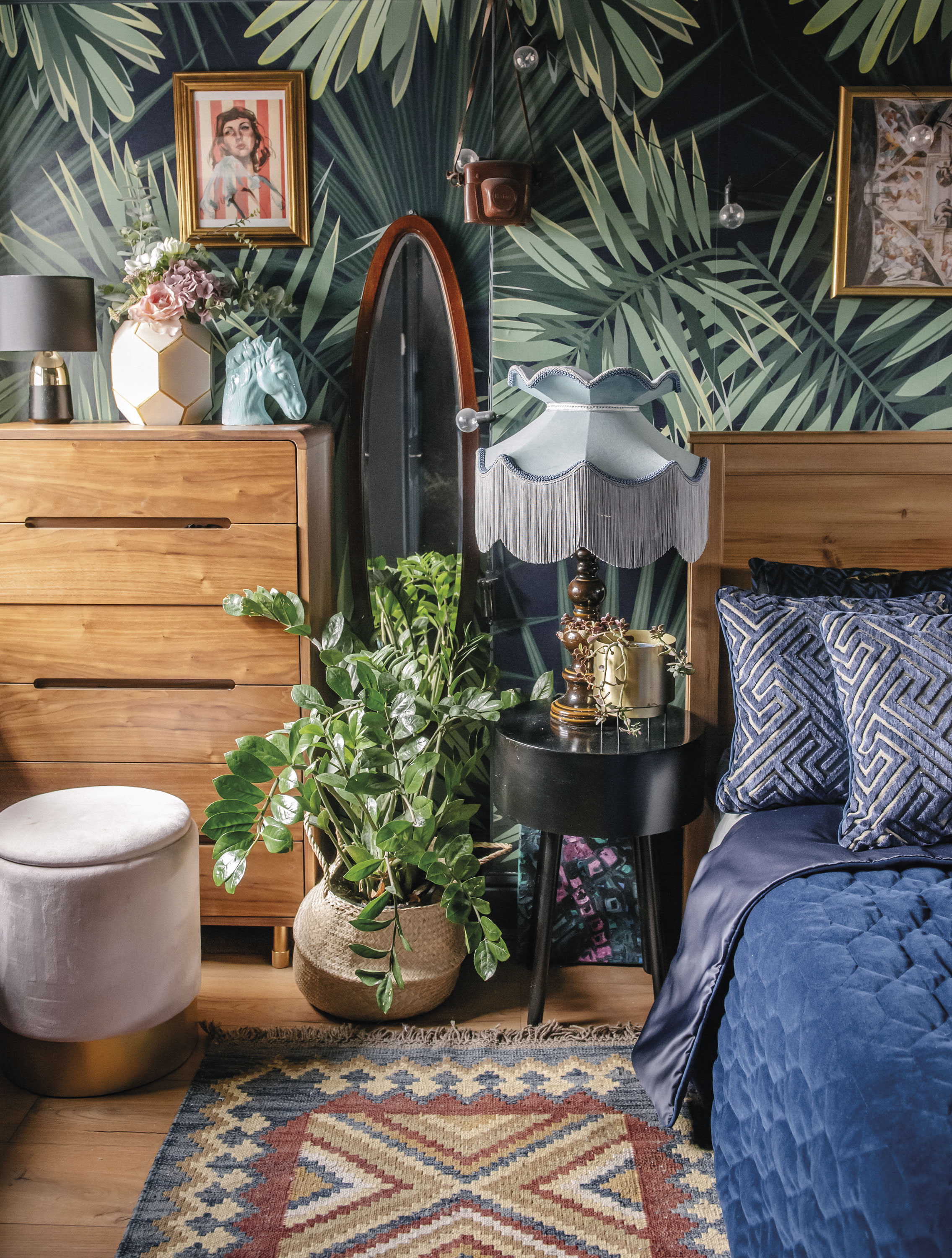 ‘I wanted our bedroom to feel like a cosy cave with an air of vintage decadence,’ Lily says. ‘I painted it in a dark blue-grey hue, and papered behind the bed with Tropical Green Plant paper from Murals Wallpaper.’ ‘I wanted our bedroom to feel like a cosy cave with an air of vintage decadence,’ Lily says. ‘I painted it in a dark blue-grey hue, and papered behind the bed with Tropical Green Plant paper from Murals Wallpaper.’