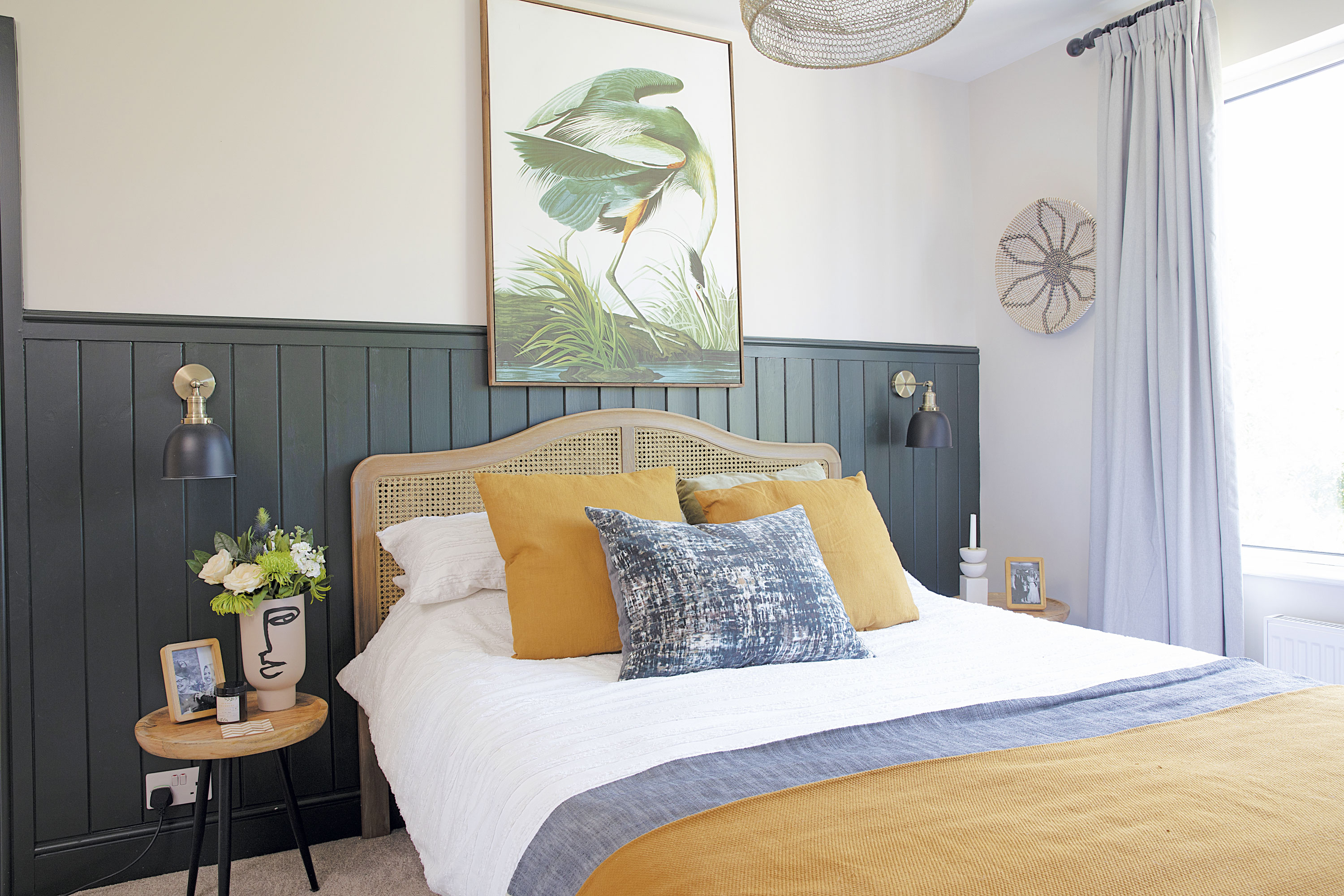 ‘Our joiner made the panelling, which we painted in Studio Green by Farrow & Ball,’ says Laura. ‘The wall lights from Iconic Lights work really well against it, and I picked two £30 side tables from Wayfair to keep costs down. I love the face vase from H&M Home too’ ‘Our joiner made the panelling, which we painted in Studio Green by Farrow & Ball,’ says Laura. ‘The wall lights from Iconic Lights work really well against it, and I picked two £30 side tables from Wayfair to keep costs down. I love the face vase from H&M Home too’