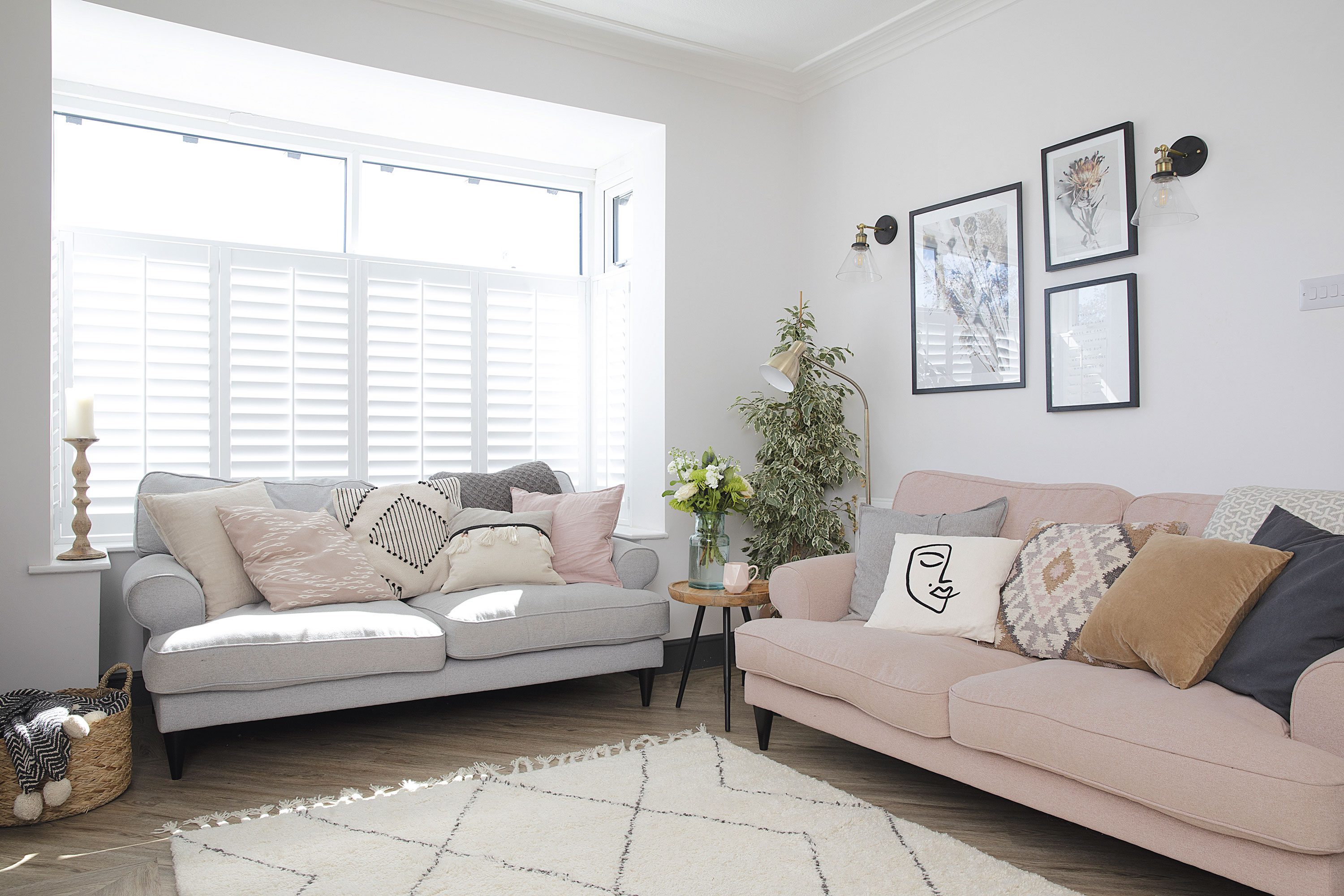 ‘Most of my cushions are from H&M Home as they’re great value and have loads of designs,’ says Laura. ‘I like mixing large block coloured cushions and a handful of boho and Scandi statement cushions at the front to create balance and interest. The artwork from Juniqe reflects my love of dried flowers and is framed by wall lights from Iconic Lights’