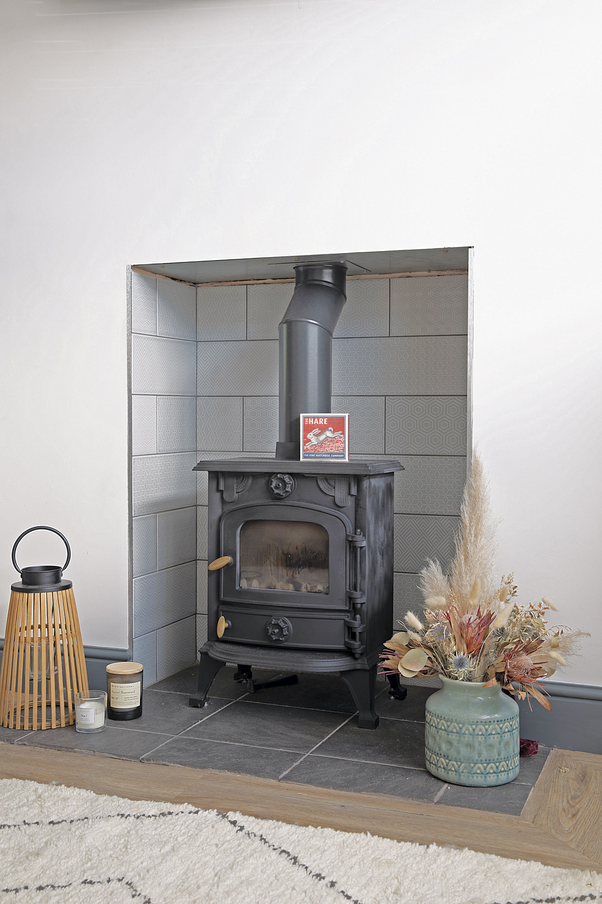 Buying a second-hand wood-burner from eBay has helped keep costs down, while simple flat matt white tiles behind make it stand out more Buying a second-hand wood-burner from eBay has helped keep costs down, while simple flat matt white tiles behind make it stand out more