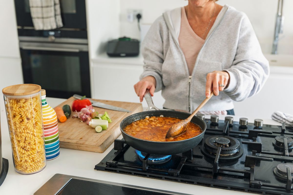 Woman cooks meal on a gas hob