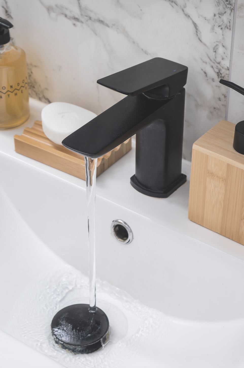 A contemporary mono mixer in a matt black finish complements the grey veining in the marble-effect tiles