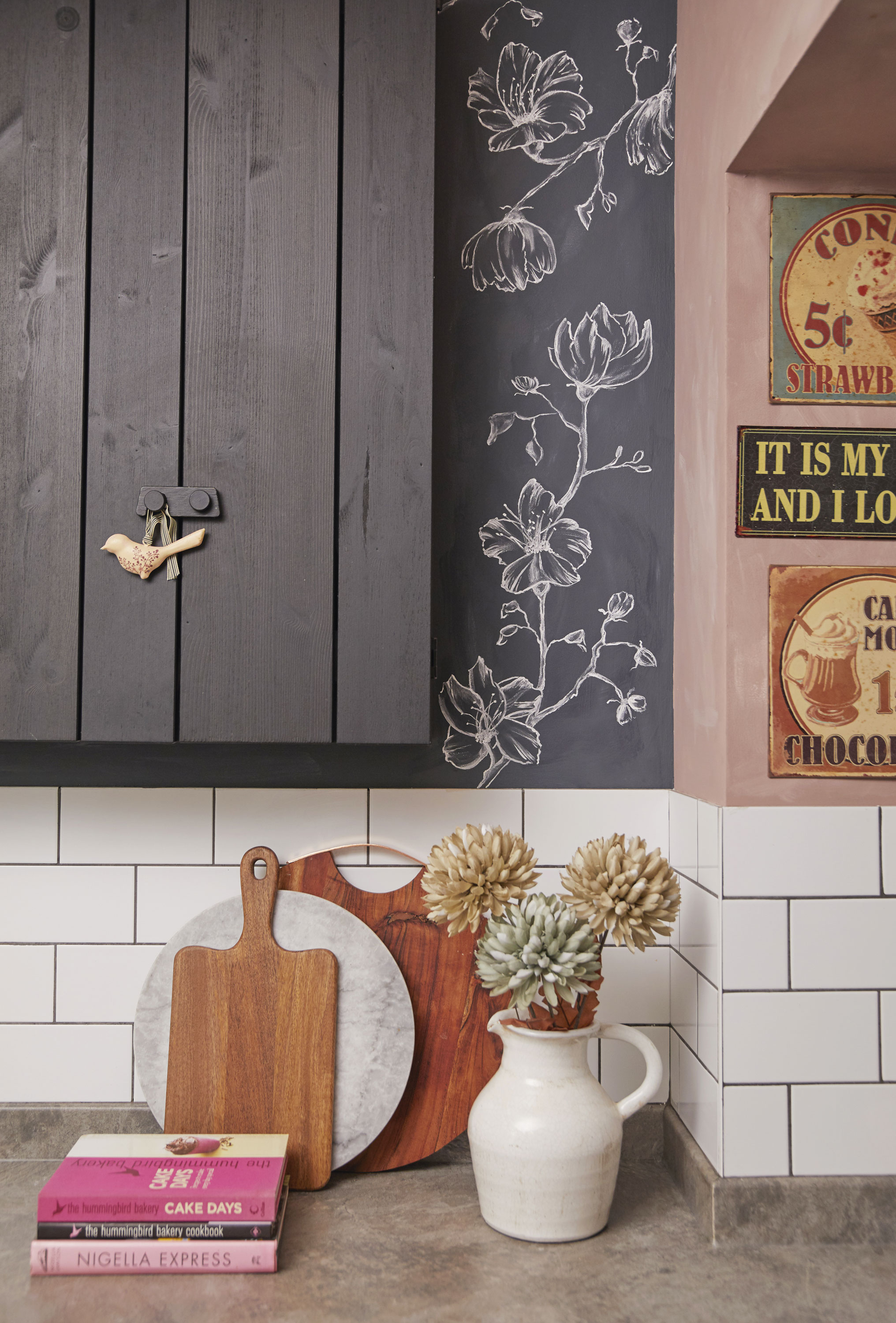 ‘This black IKEA cupboard is really narrow so it’s perfect to store my glasses, but not deep enough to take over the space, as I didn’t want bulky overhead cabinets. The wall is painted with blackboard paint that I’ve decorated with hand-drawn flowers for a pretty finish’