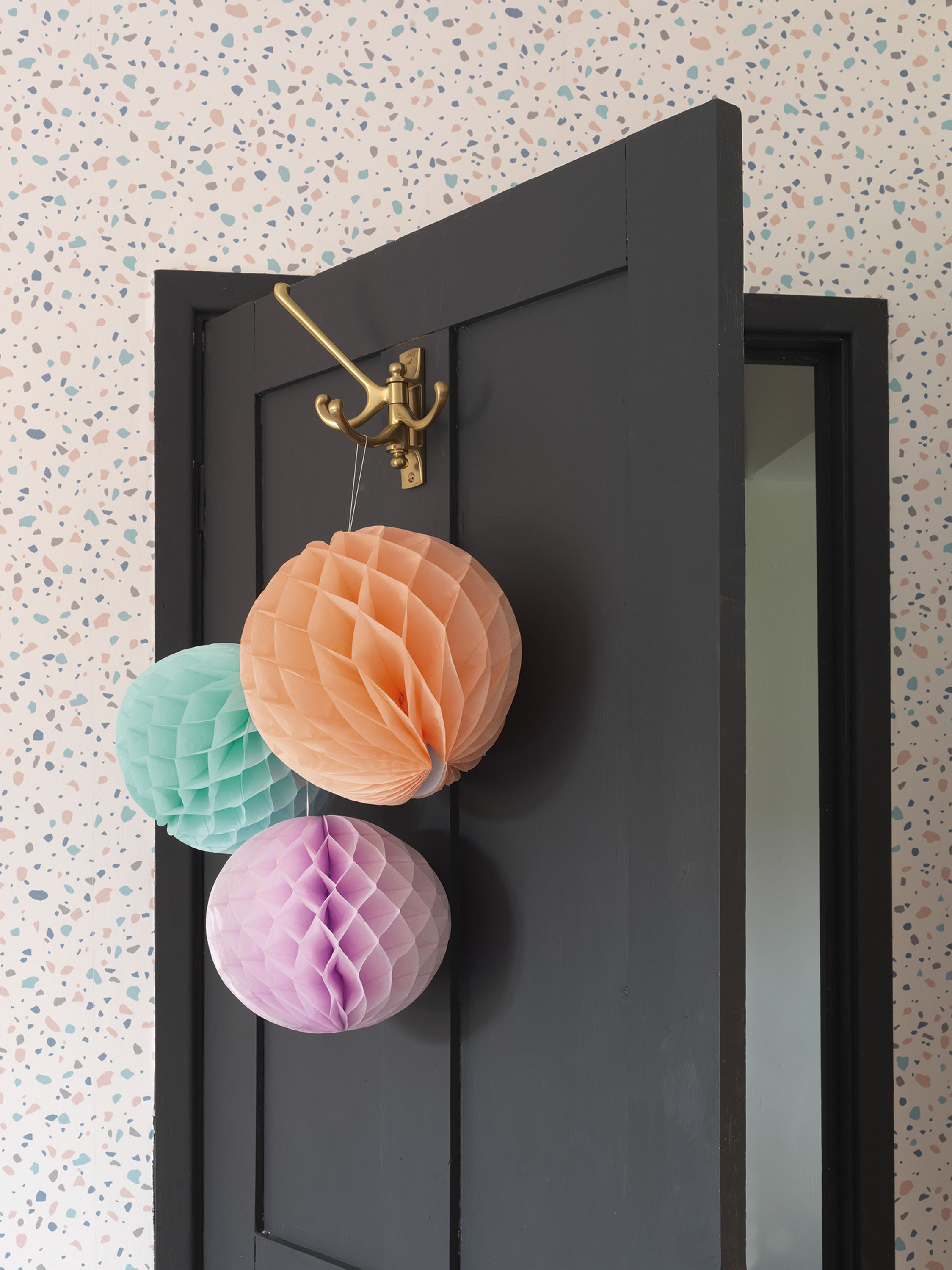 'Our home is cool & quirky with a bit of edge' Raya already had the honeycomb paper decorations but realised they perfectly matched the colours in the B&Q terrazzo wallpaper. ‘I just thought, why not keep them up?’ she says