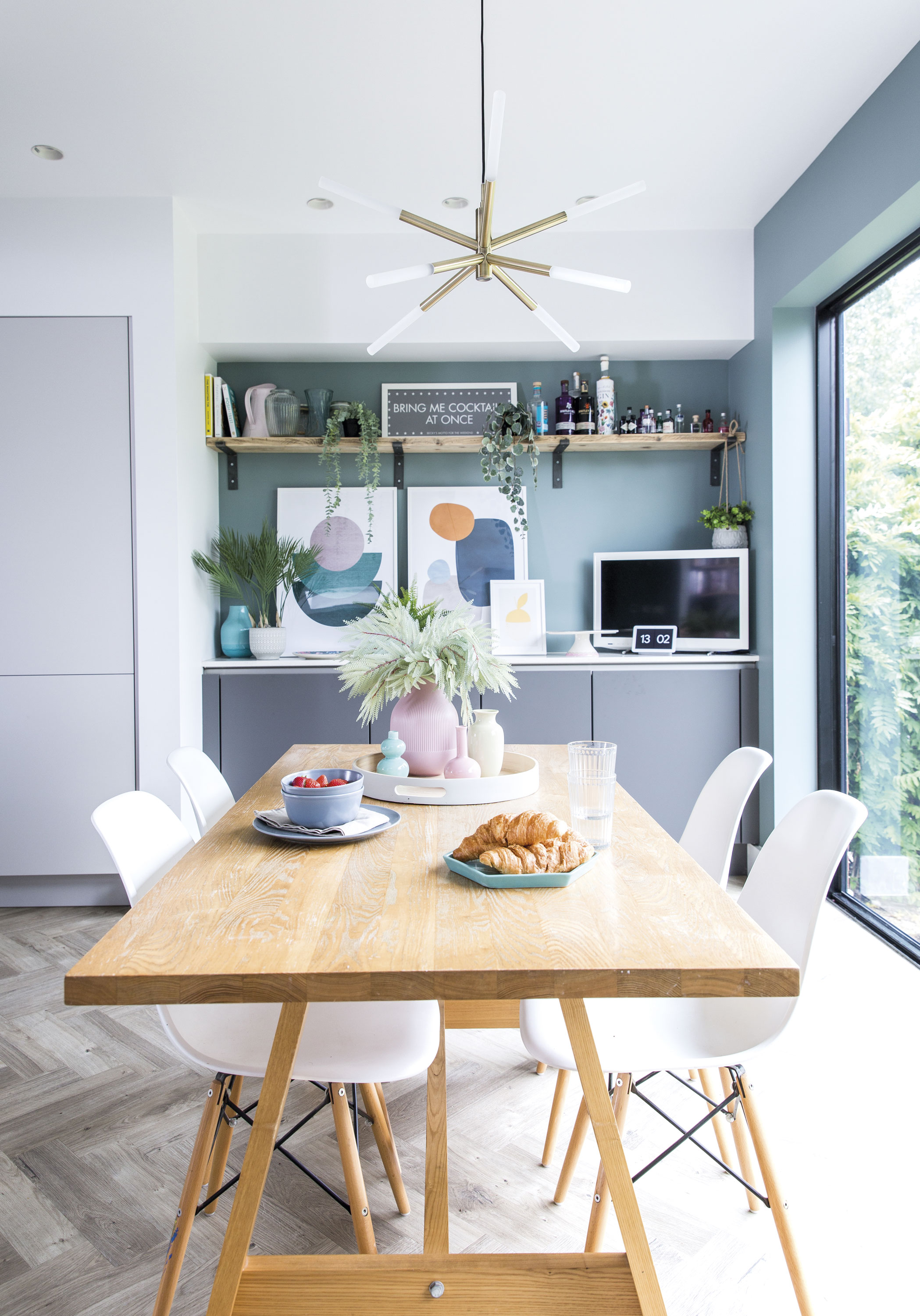 The dining table sits under an impressive chandelier by the large sliding doors, ensuring the area gets plenty of natural light too