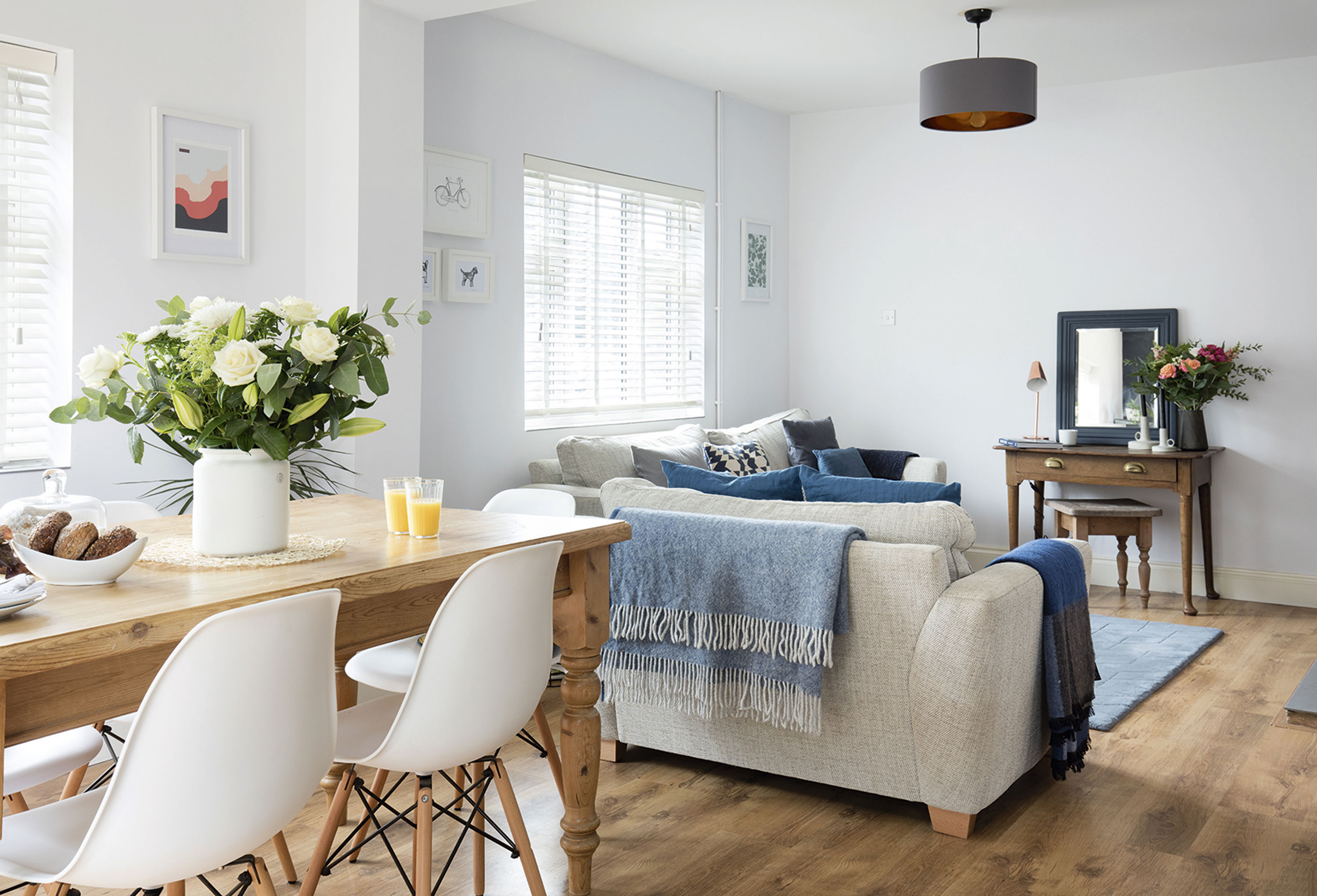 Greer has piled up inky blue cushions and throws to cosy up the room and complement the dark blue in the kitchen area