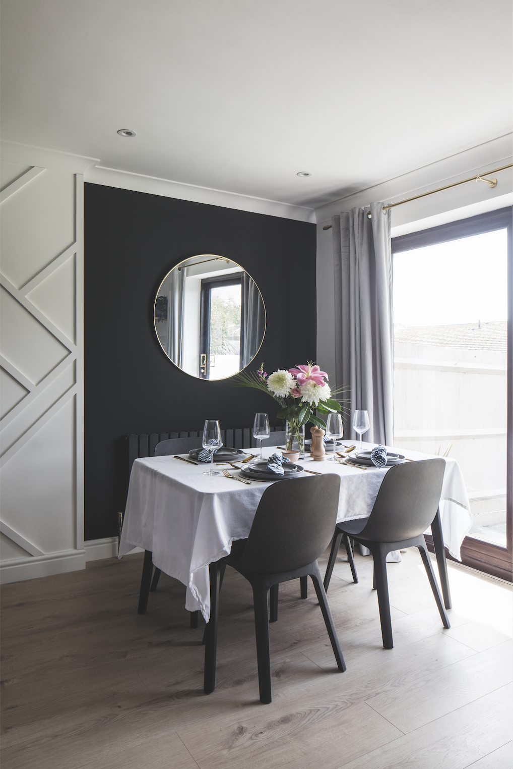A white geometric panel between the dark walls zones the open-plan space, and Becca has brightened up the black wall behind the dining area with a round brass mirror. ‘It looks better in this alcove as it reflects the kitchen, rather than the TV,’ says Becca A white geometric panel between the dark walls zones the open-plan space, and Becca has brightened up the black wall behind the dining area with a round brass mirror. ‘It looks better in this alcove as it reflects the kitchen, rather than the TV,’ says Becca