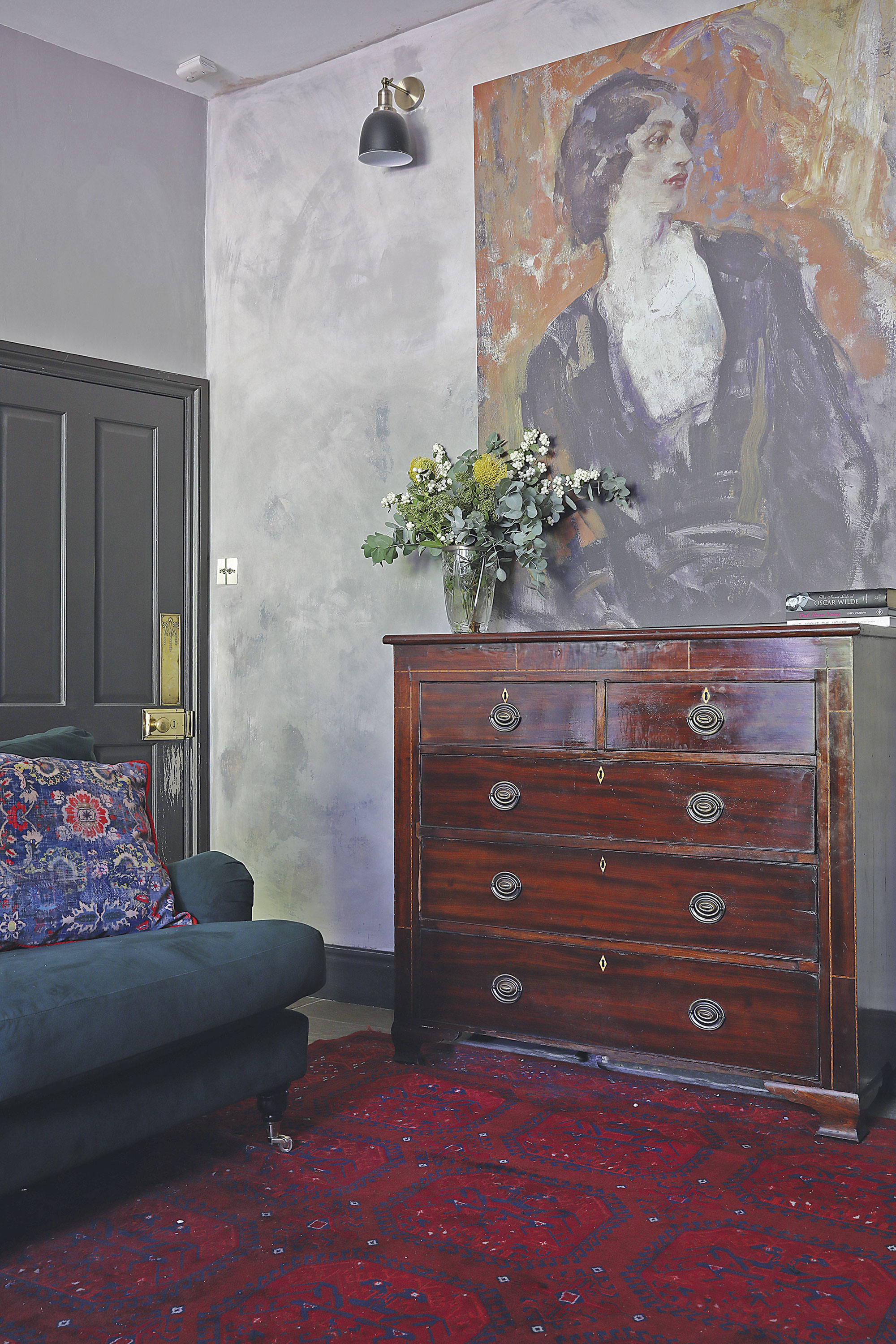 Home makeover: 'Our style is a modern take on traditional' ‘My husband, Trevor, gave this wall a broken plaster effect using different paints. I knew I wanted a strong bold piece here and found this canvas at Surface View. It’s called Lillah McCarthy by Ambrose McEvoy from their National Portrait Gallery collection. The chest of drawers was inherited from Trevor’s mum and works well with the antique Persian rug’