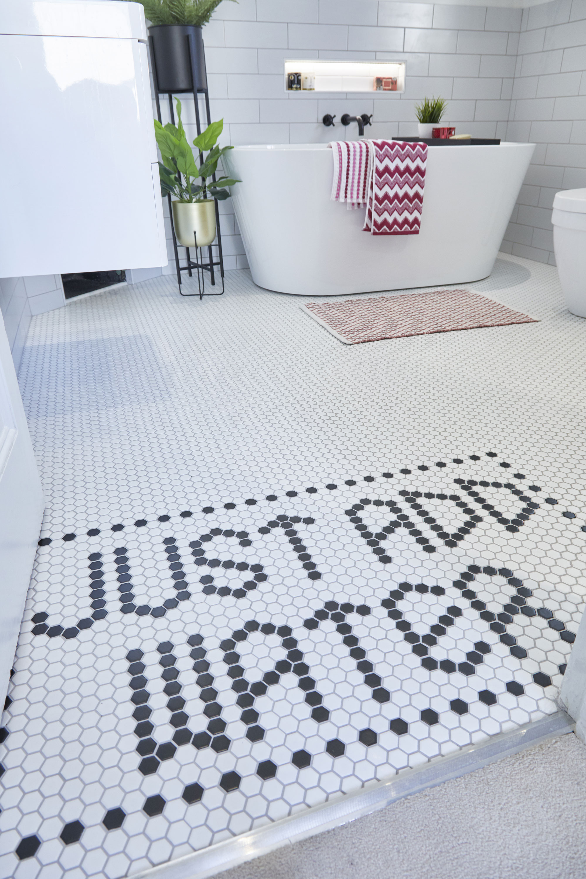 Adding statement tiles sparingly was initially down to budget constraints, but Emily has used it to her advantage, creating a shower enclosure with starburst tiles and a fun entrance with ‘Just add water’ spelled out in black
